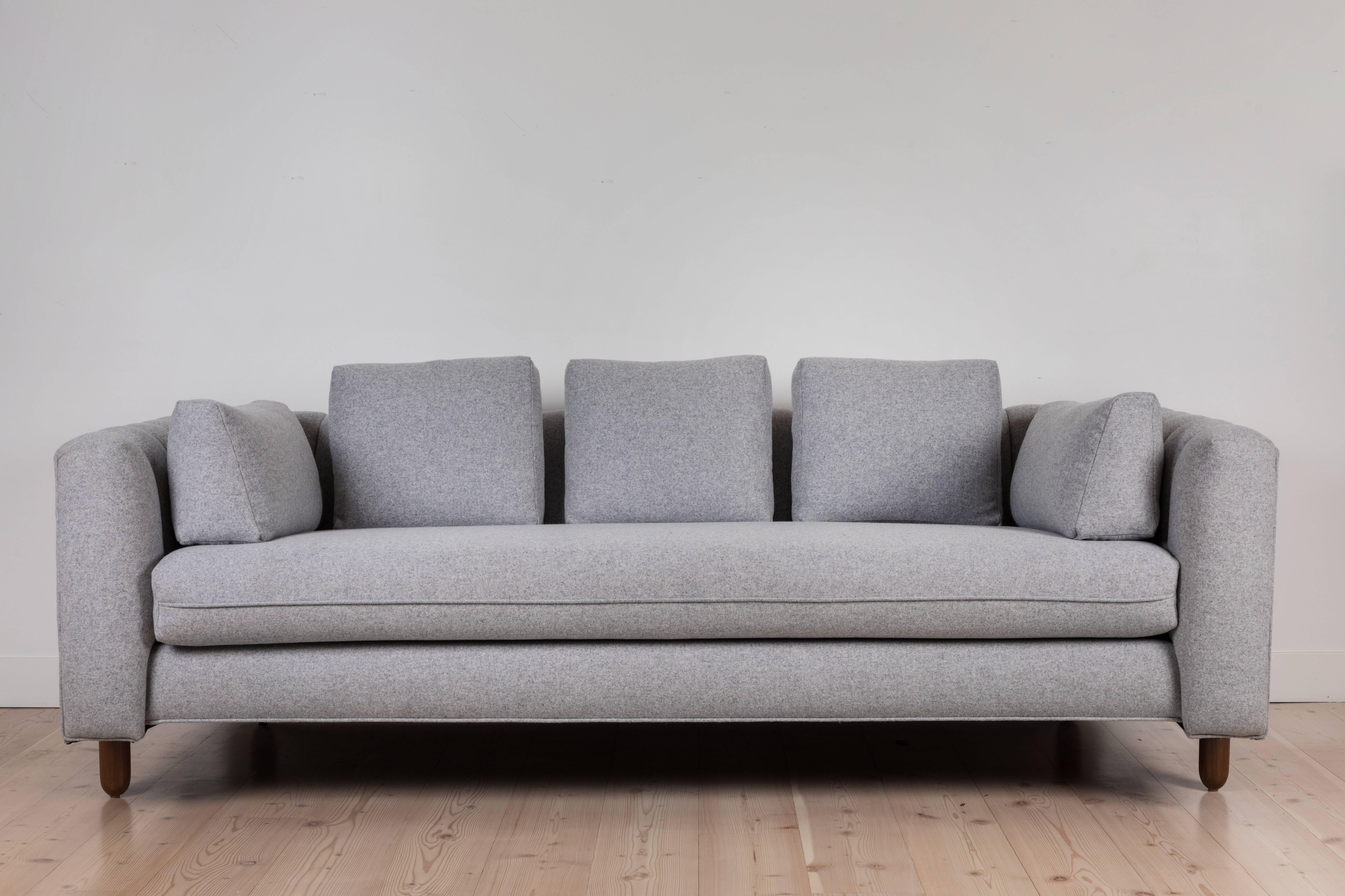 The Isherwood Sofa features a channel tufted body with loose bolster cushions. The turned legs are made of solid white oak or American walnut and are inset on the sides revealing the leg detail.

Available to order in Customer's Own Materials with a