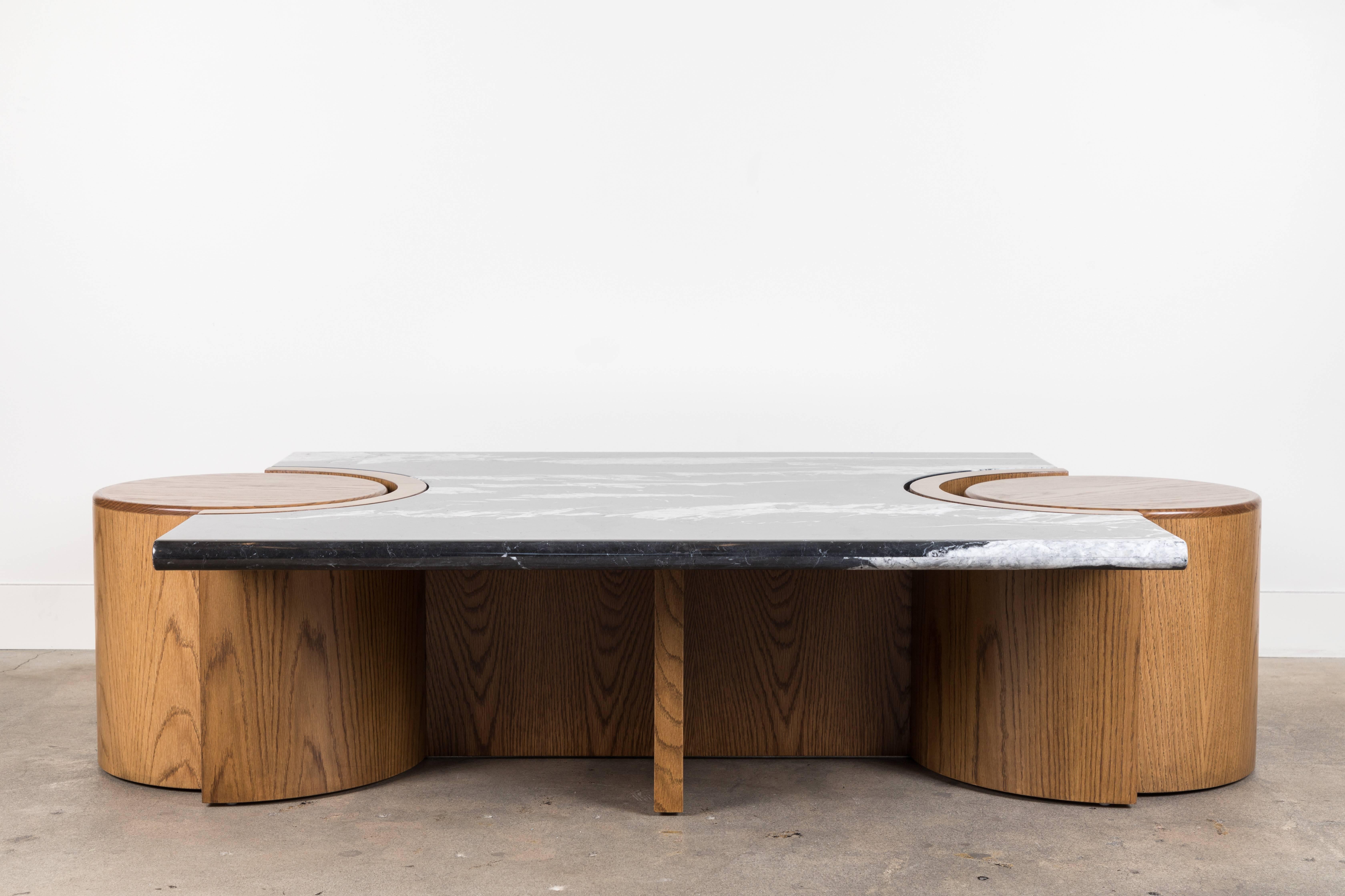 The Prospect Coffee Table features a stone top that rests atop a sculpted American walnut or white oak base with two cutouts for drum tables on either end. Shown here in Negra Marquina Marble and Oiled Oak.

Dimensions: 64
