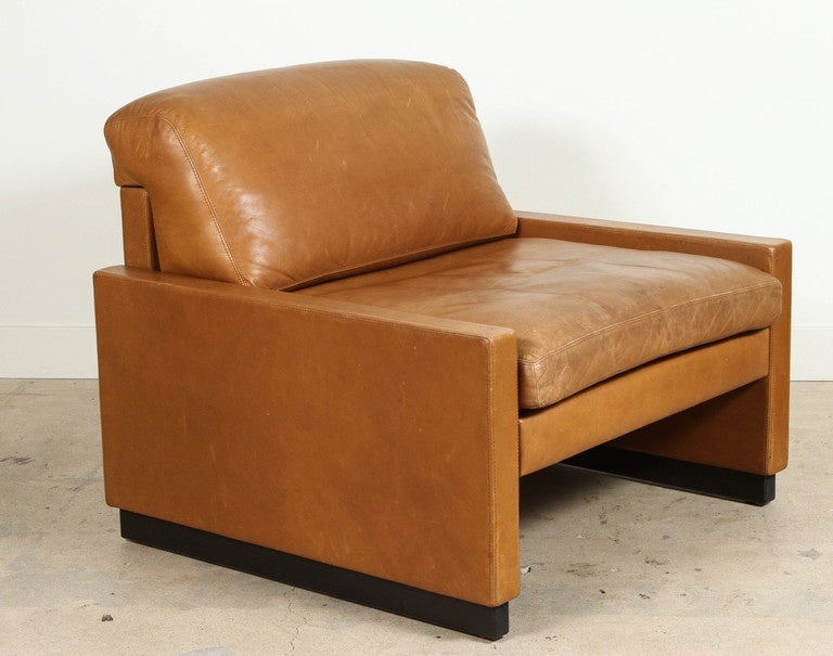 Pair of leather armchairs by Straub feature low, square arms with removable seat and back cushions. Bases are ebonized walnut.