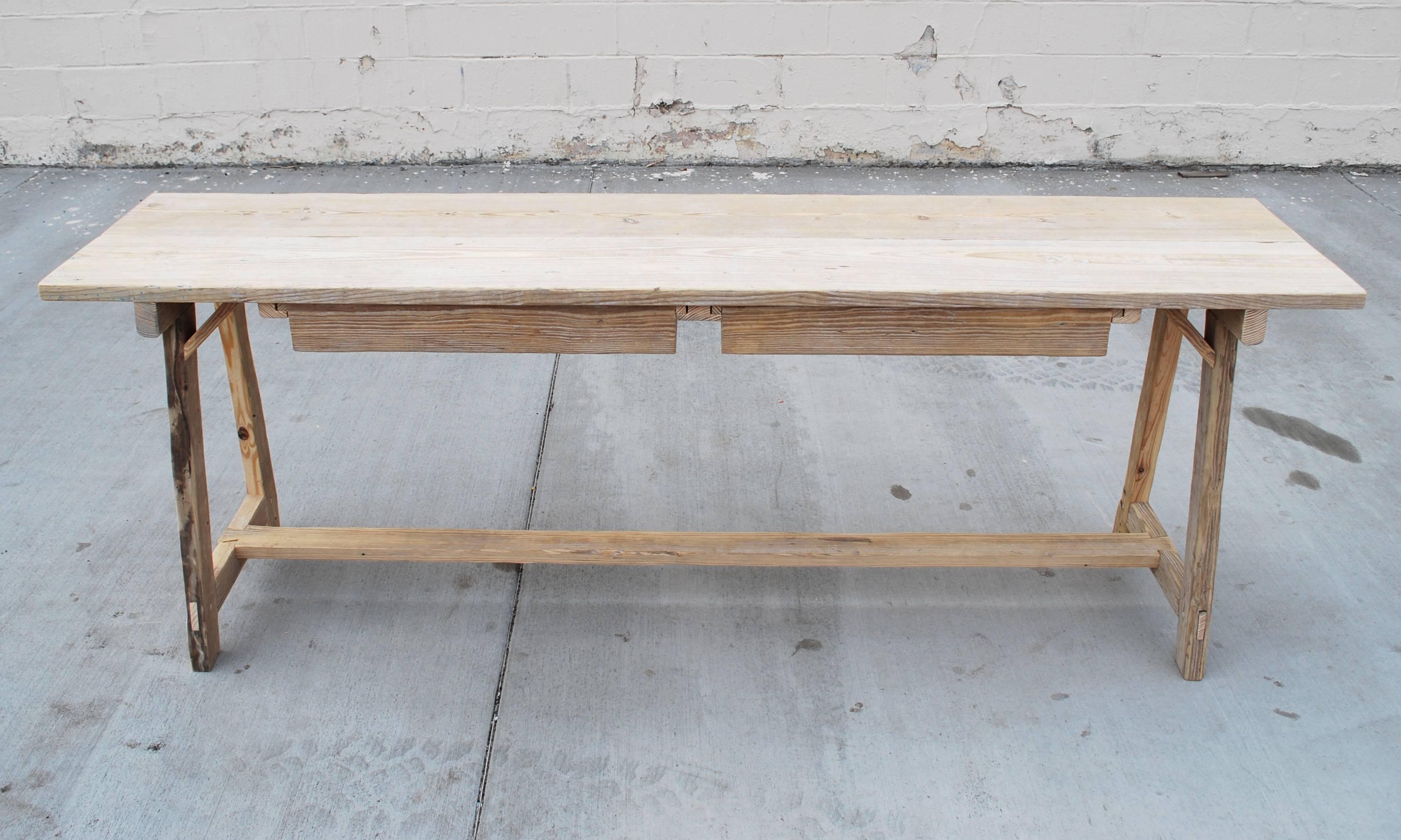 Cette table console en pin recyclé a une belle patine, ses pieds sont évasés dans l'axe de la longueur et de la largeur et elle possède deux grands tiroirs pouvant être tirés de chaque côté.

Comme chaque table est fabriquée dans notre propre