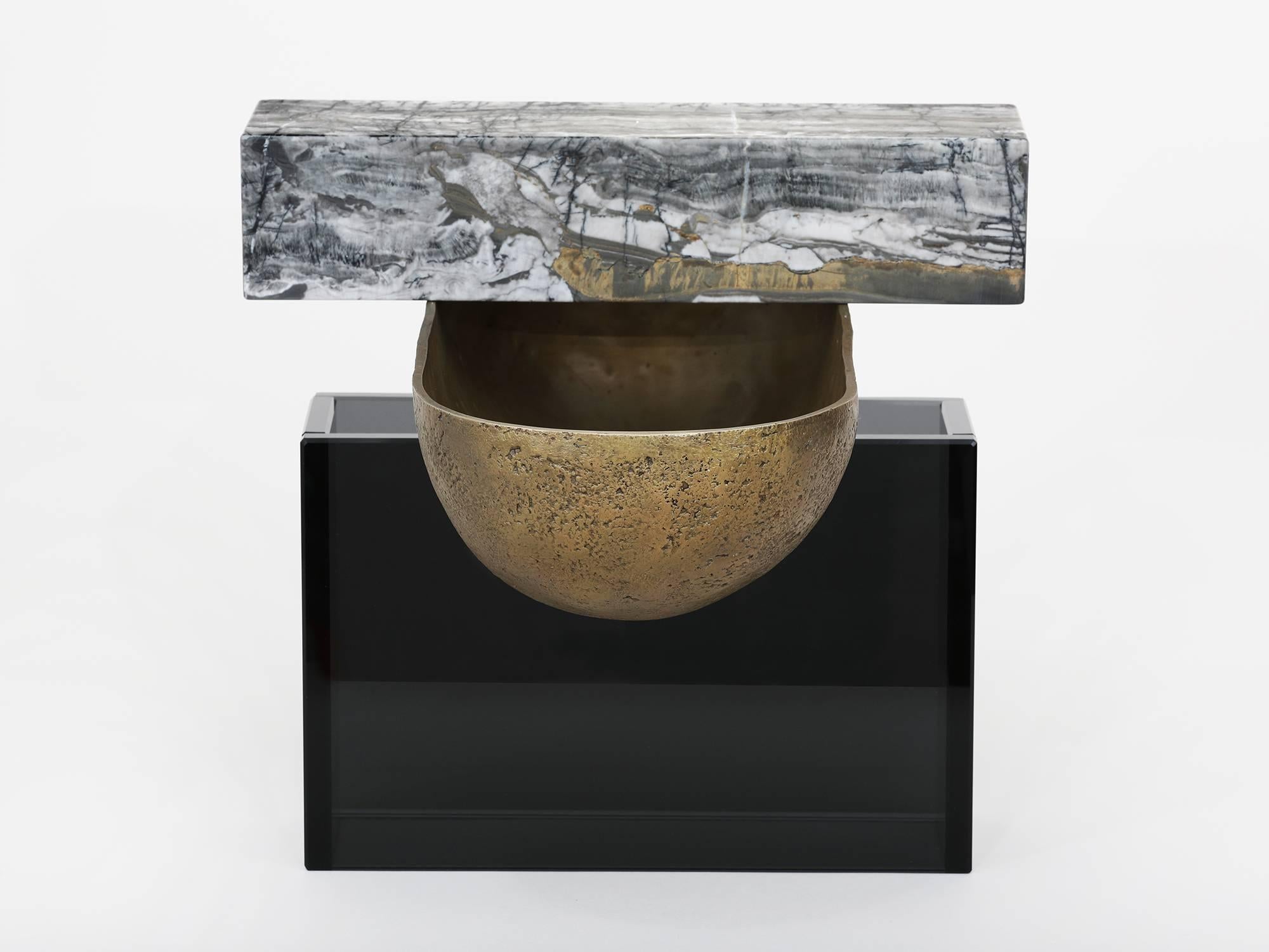 L'un des trois vaisseaux développés comme maquettes de matériaux pour les œuvres plus grandes de Brian Thoreen. Composé d'un bol en bronze moulé, de marbre gris et de verre gris. Disponible également en marbre brun ou rouge et en verre bronze.