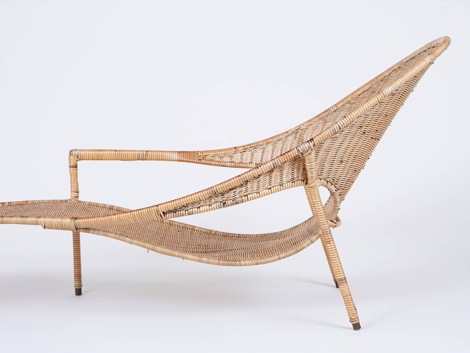 Asymmetric and sculptural lounge chair of plasticized wicker over galvanized iron with brass feet, by California designer Francis Mair.
