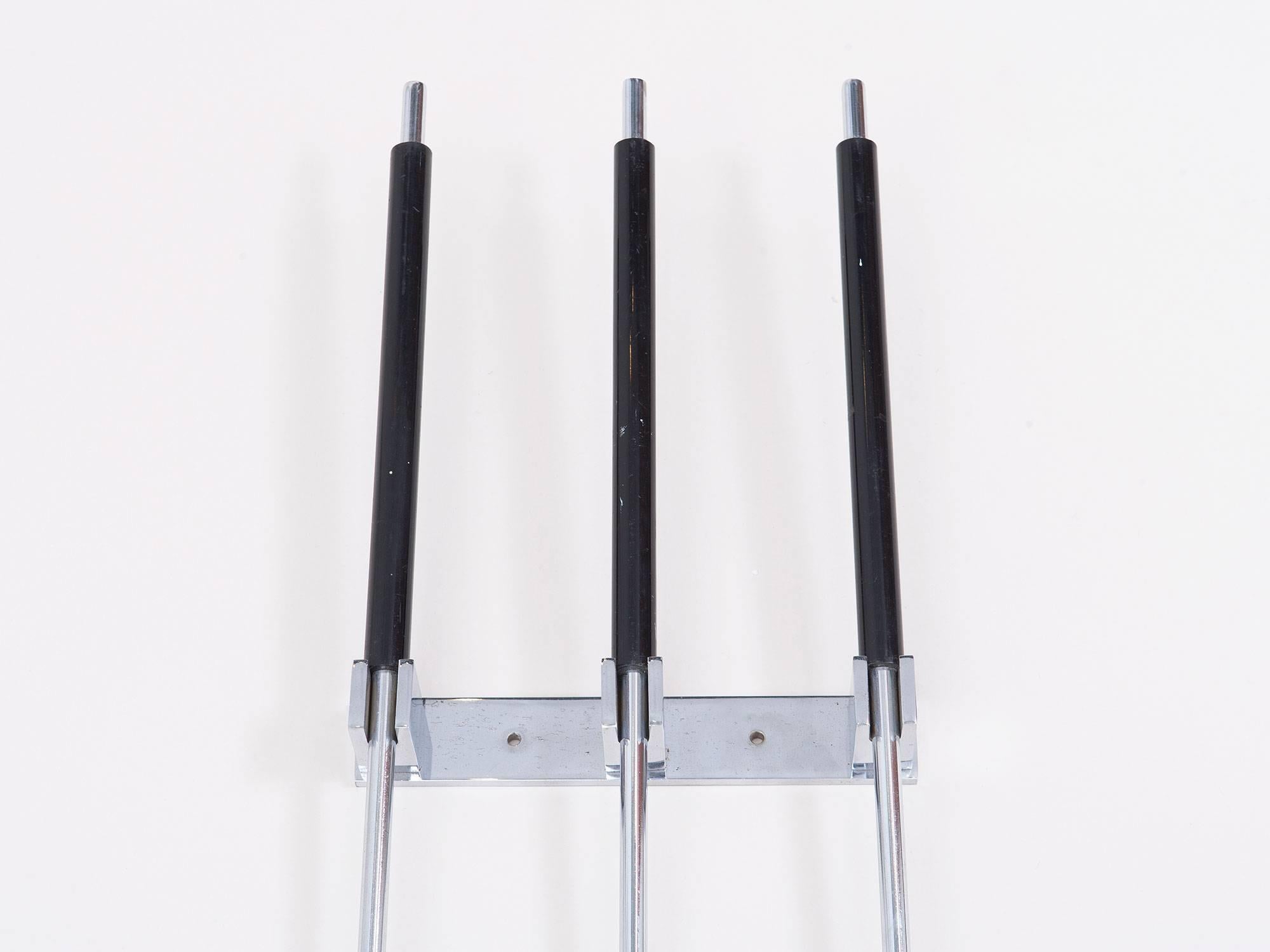 Unusual three-piece set of chrome-plated fireplace tools that hang on the wall, made by the Italian company Albrizi in the 1960s. Consists of a brush, poker and shovel with black lacquered handles and a chrome a wall mount.
