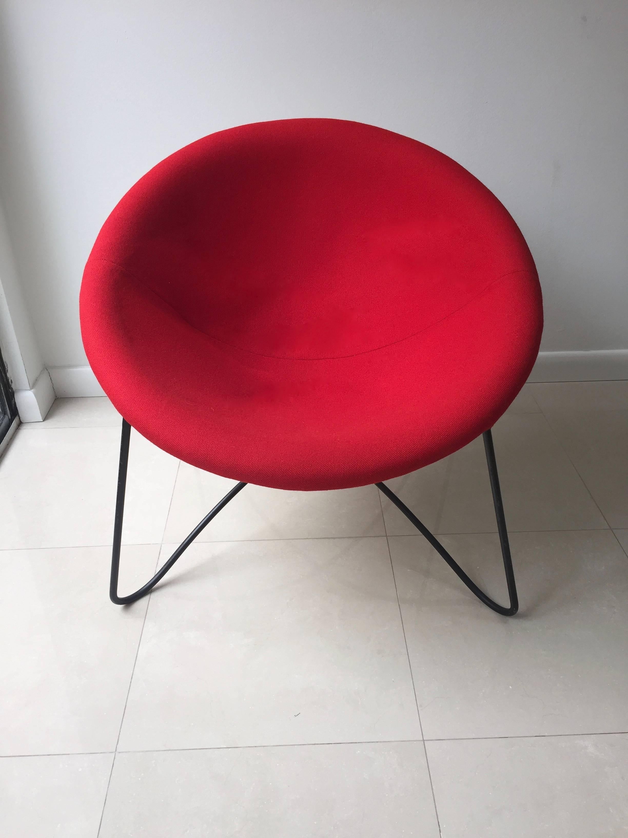 Round chair has fiberglass seat with original red fabric supported by a tubular steel base finished in black lacquer.