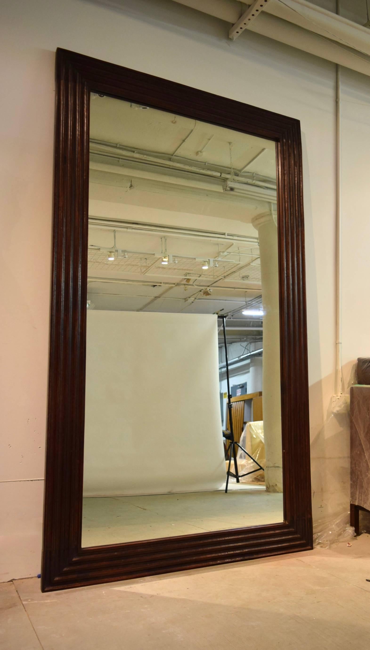 A pair of large scale, full length mirrors with hand fluted solid wood frames, both in very good, original condition. Both mirrors are ready to hang horizontally or vertically, and they can also be used as a floor mirror leaned against a wall as