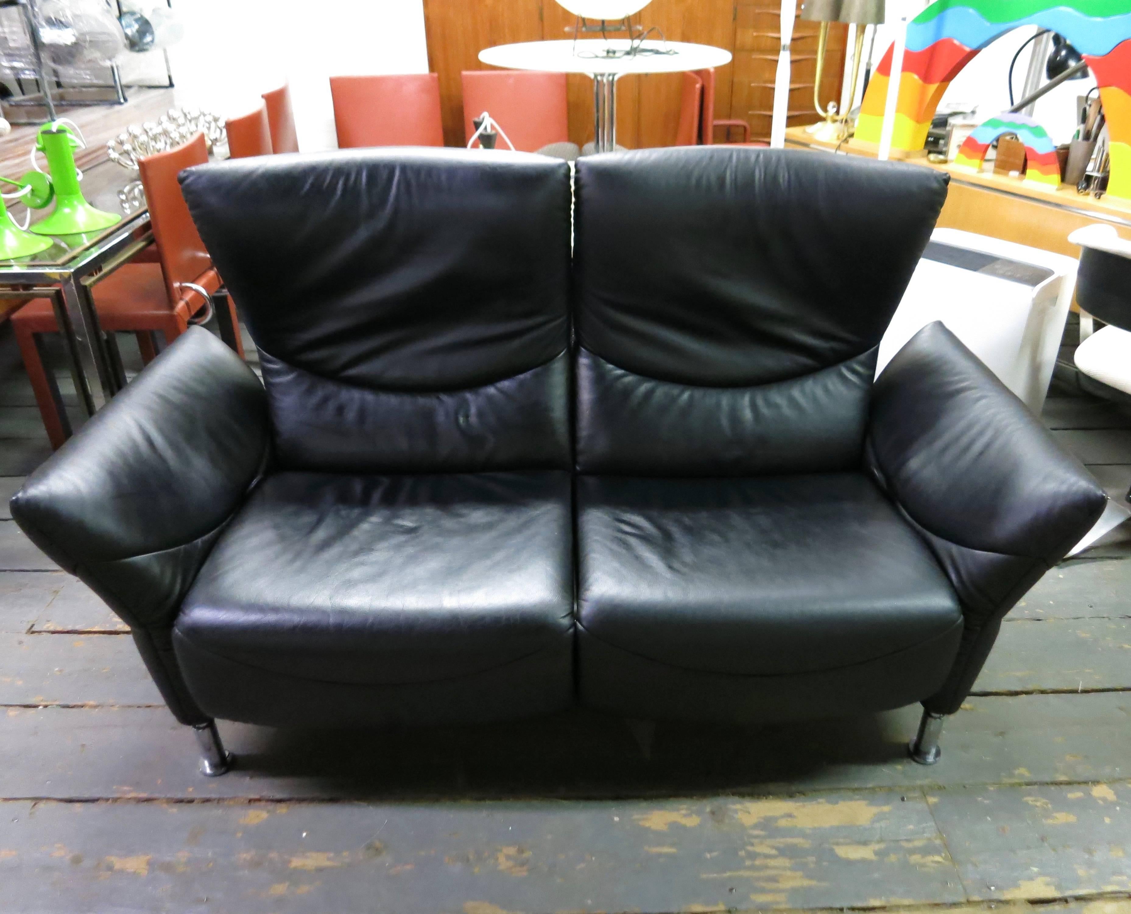 Black leather sofa or loveseat that converts to a lounge-sleeper for two. Each side has independently reclining backrests, arms that pull down and seats that both pull outward and forward, all allowing for both sides to act separately as a double