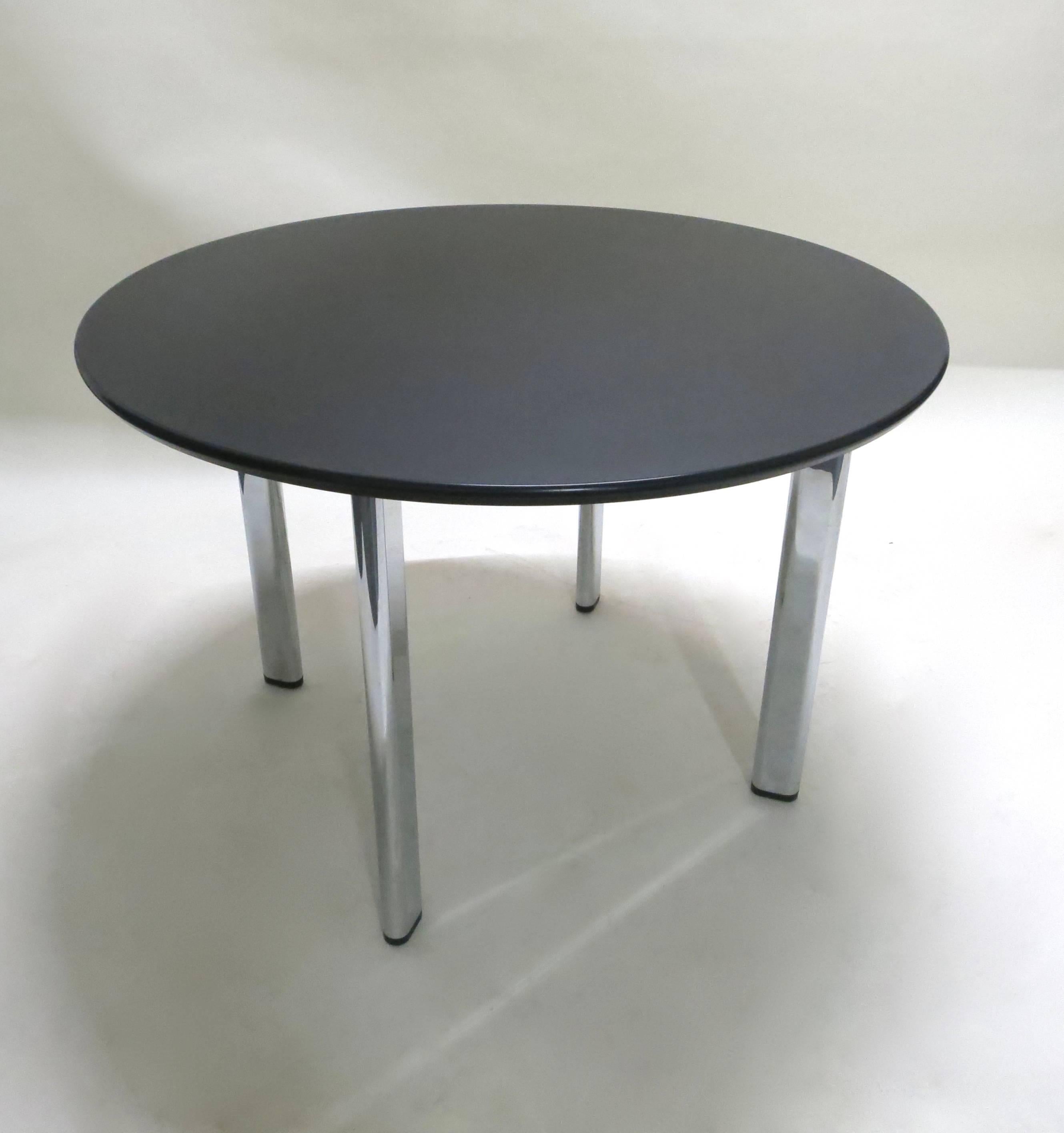 Dining or work table with four chromed legs and a round, black laminate and vinyl bullnose edge top, all in excellent condition.