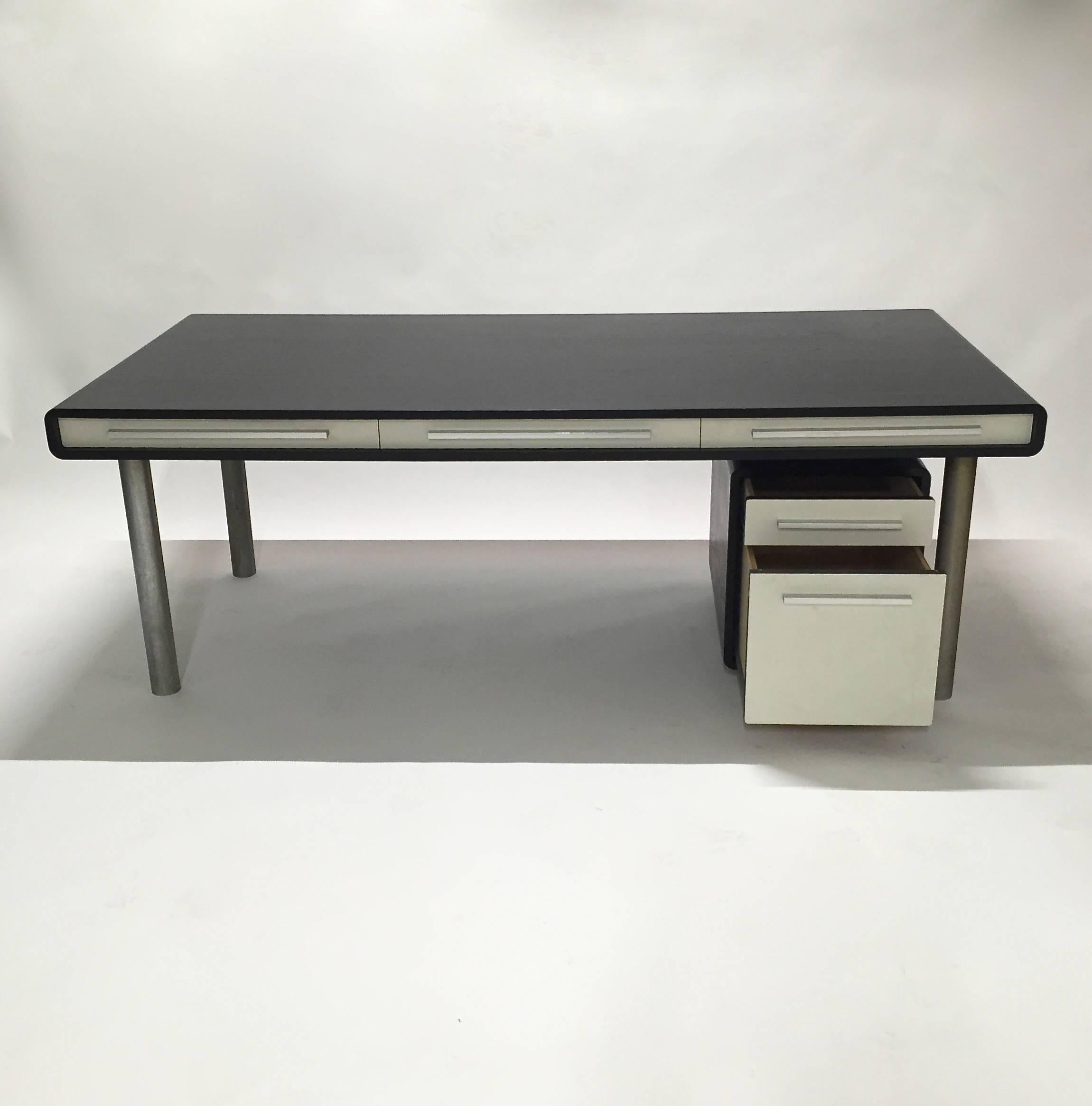 Three-drawer executive desk with an ebonized wooden top, steel legs, aluminium handles, and white textured laminate detail. 
Storage or filing cabinet measurements: 53.5 cm H x 42 cm W x 60 cm D.