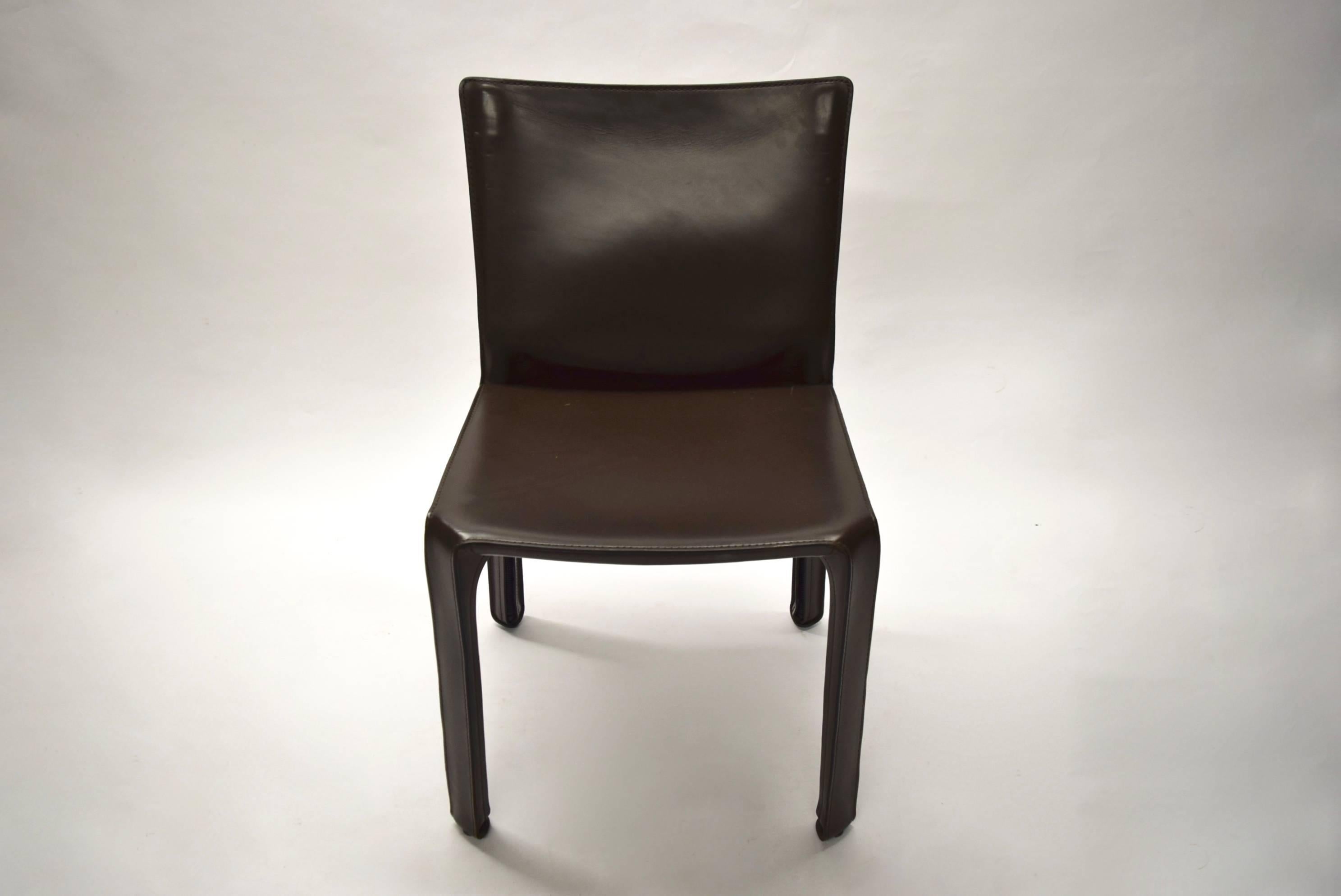 Set of eight dining height CAB armless chairs in brown leather all with original markings an all in excellent condition. The chair is steel covered in leather. The seat cover is applied using zippers that are not visible.


