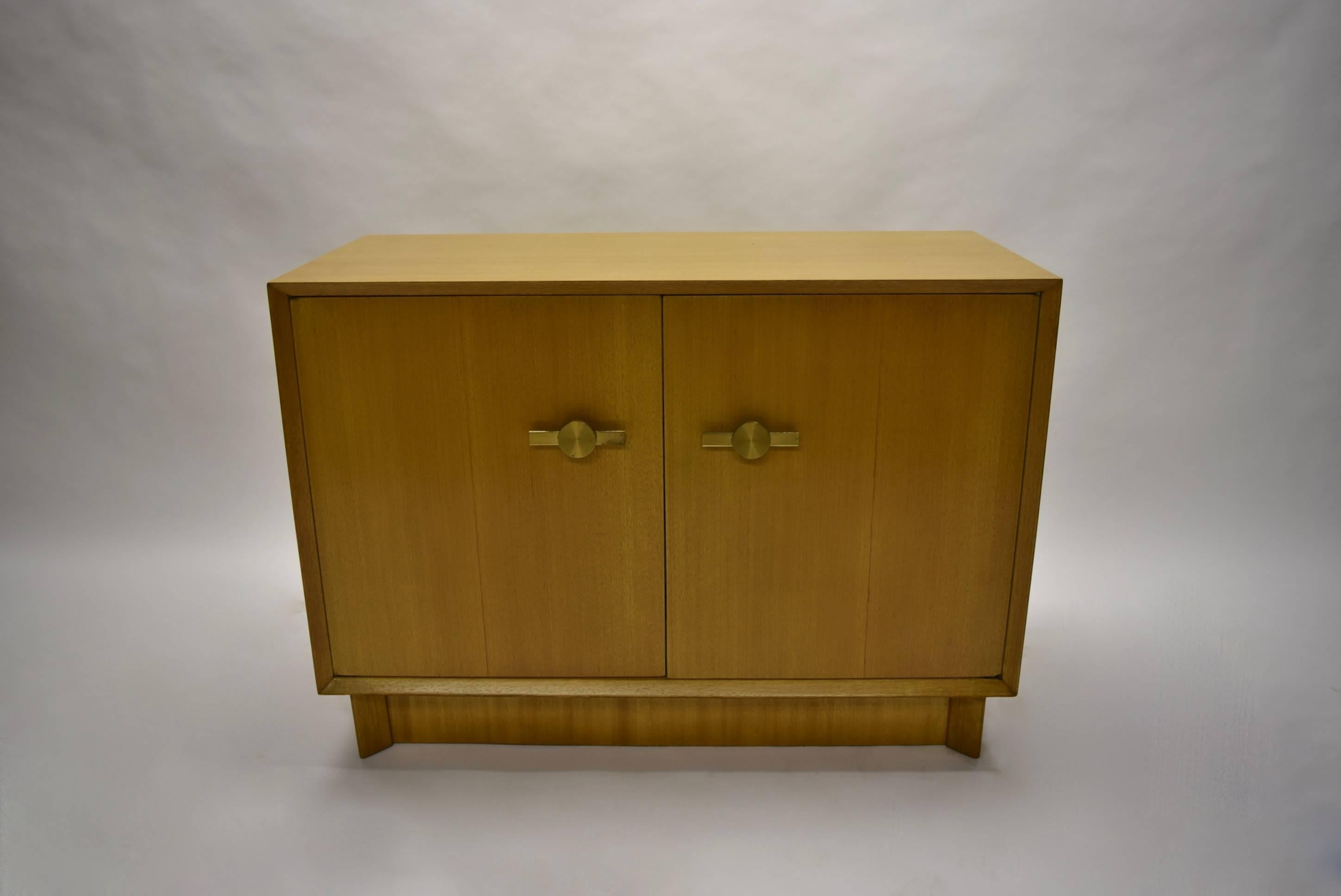 Pair of cabinets both with two doors and matching solid brass pulls. One cabinet opens to reveal four centre drawers flanked by a single shelf on either side. The second opens to a single adjustable shelf. Both have been completely refinished.