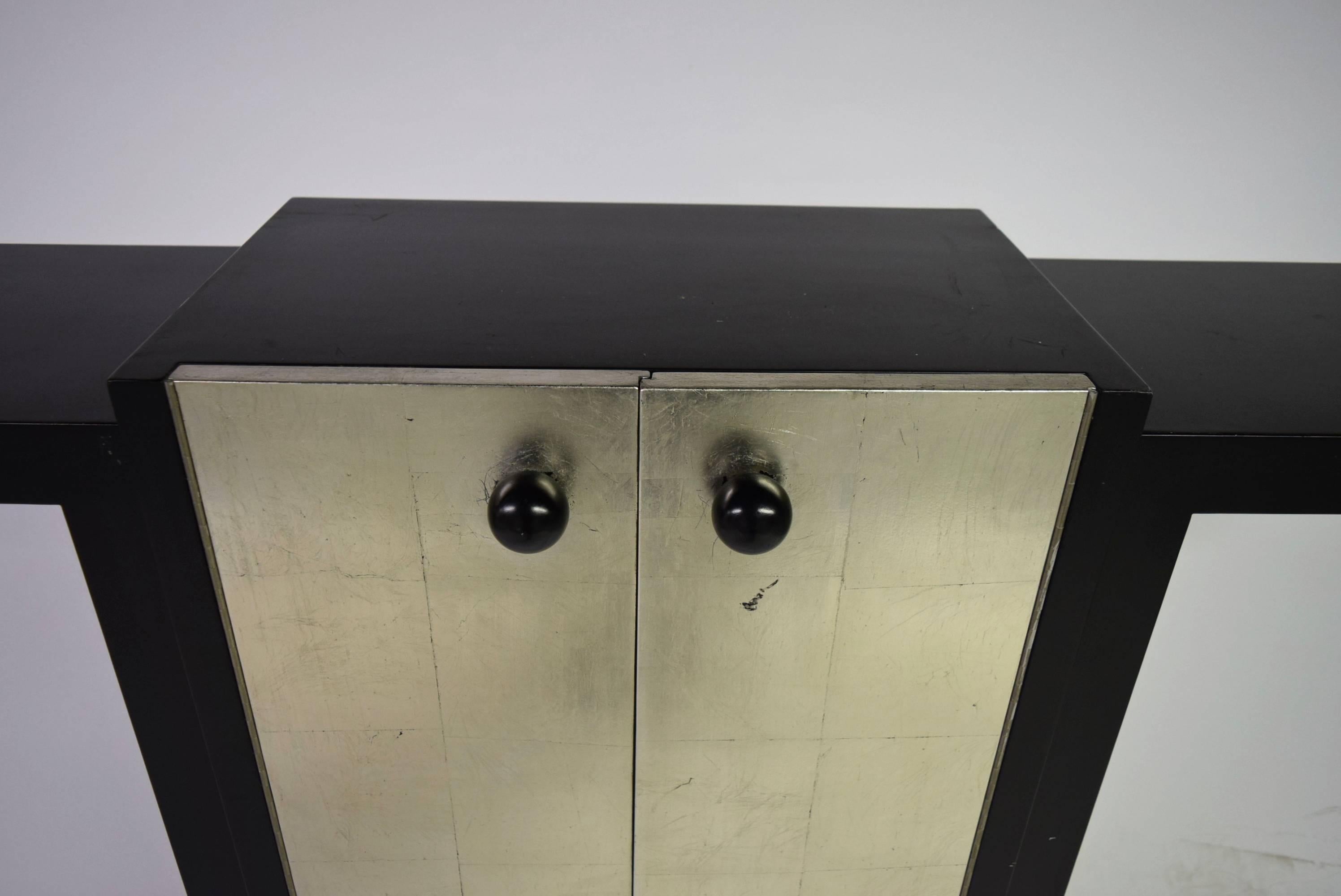 French Deco Console in black lacquer has a centre cabinet with two doors in silver leaf.