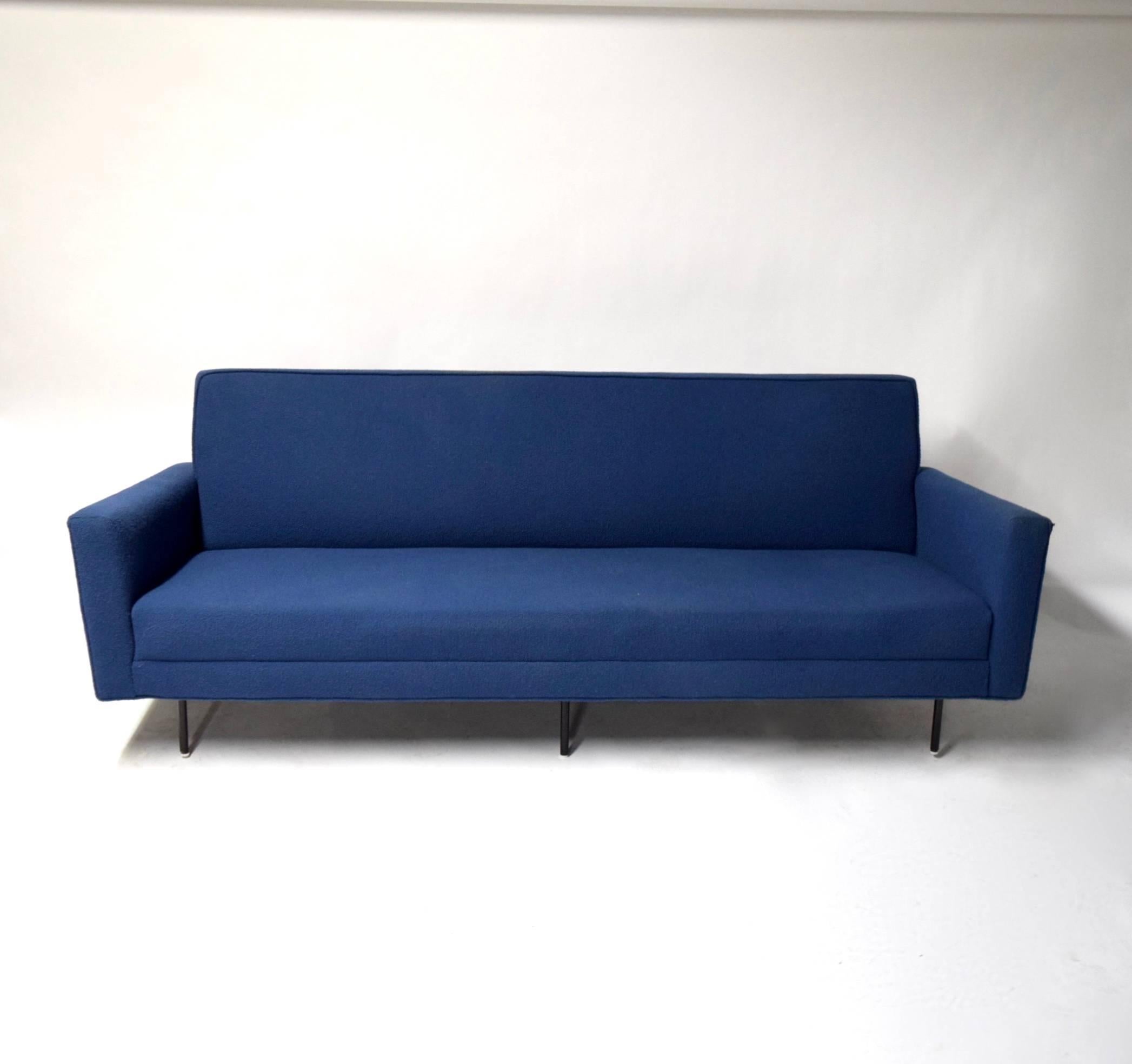 Early Knoll sofa has been reupholstered using a blue Knoll fabric. The seat, back and sides are sewn into the frame and supported by six black, enameled, tubular steel legs.