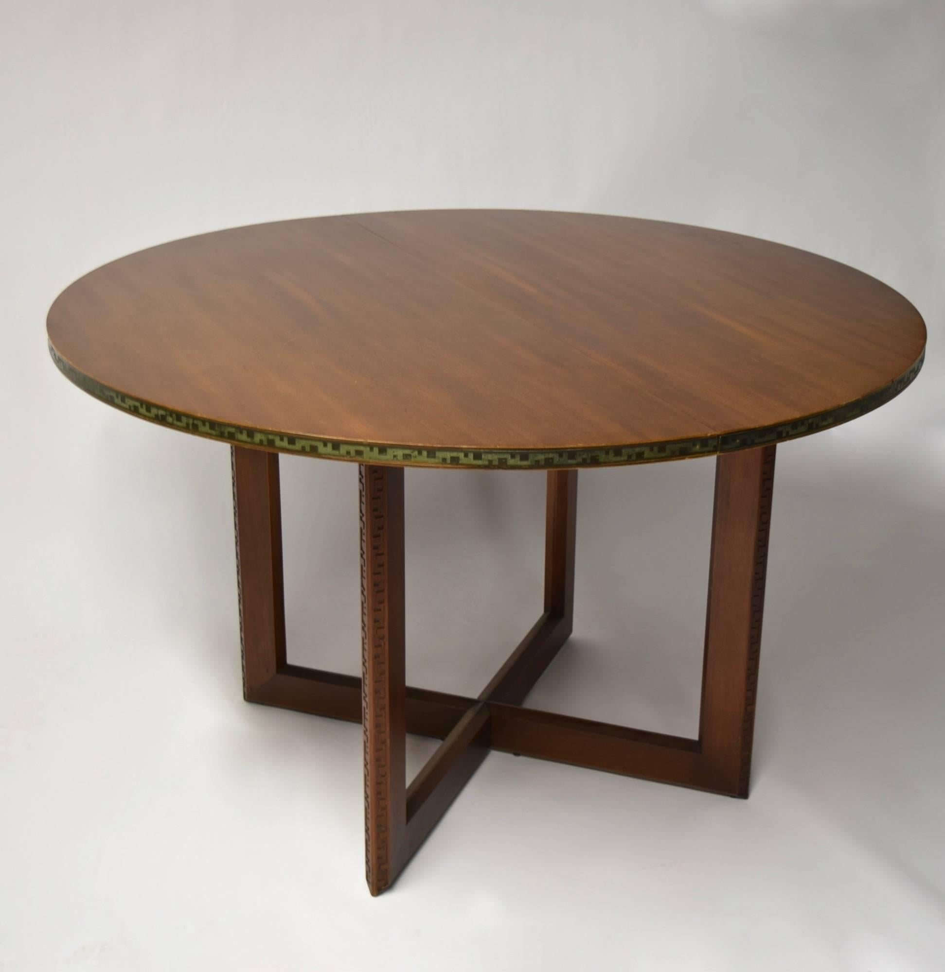 Frank Lloyd Wright for Heritage-Henredon Taliesin dining set comprises a round, extendable dining table and eight dining chairs; two armchairs and six side. The table has an embossed copper banding with great patina along its circumference and