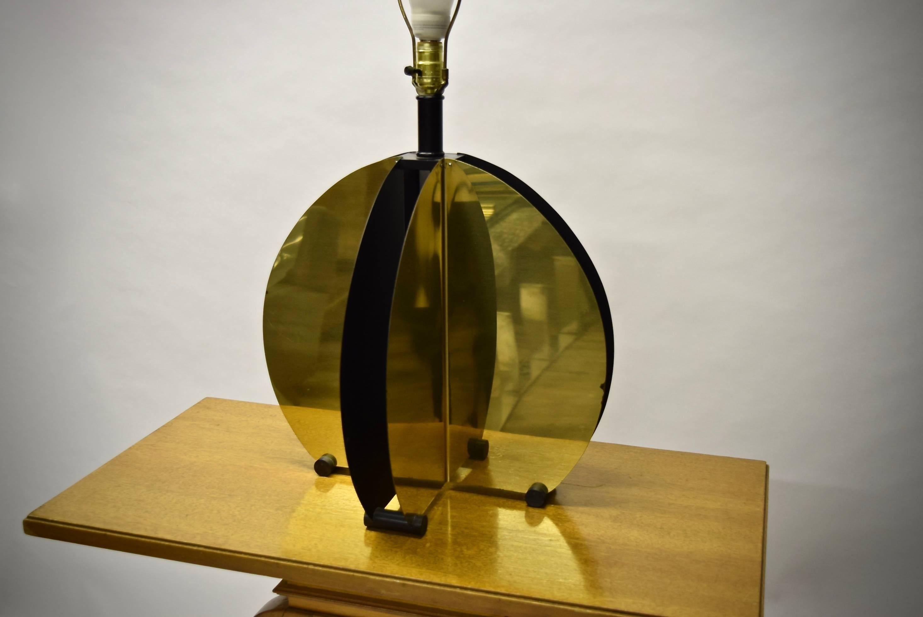 Pair of dimensional table lamps made of four main sections: each crescent-shaped section is formed by one piece of flat metal, enameled in black on one side and brass plated on the other that has been folded in the centre and supported by a black