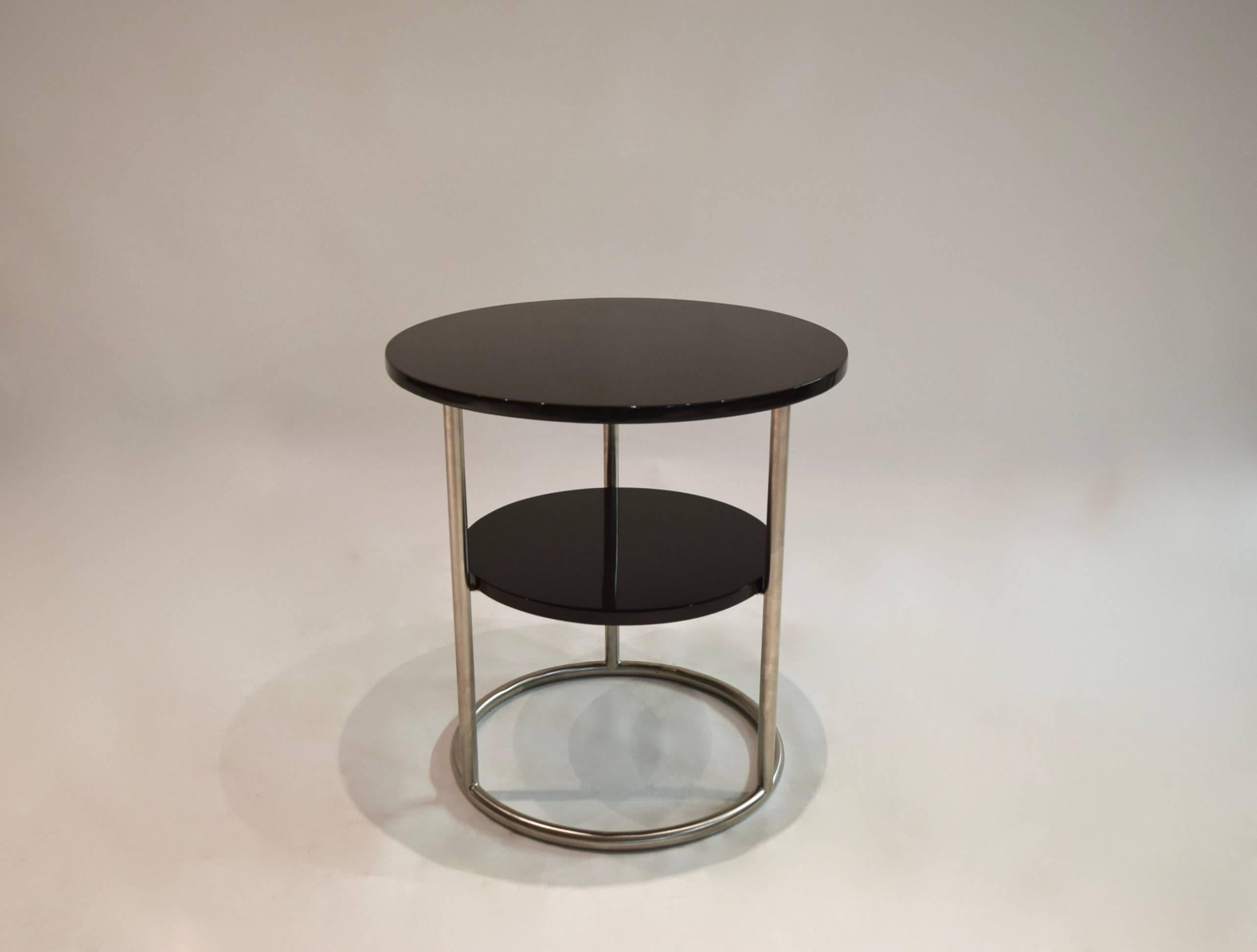 Pair of round side tables with a brushed tubular steel frame that supports a 16