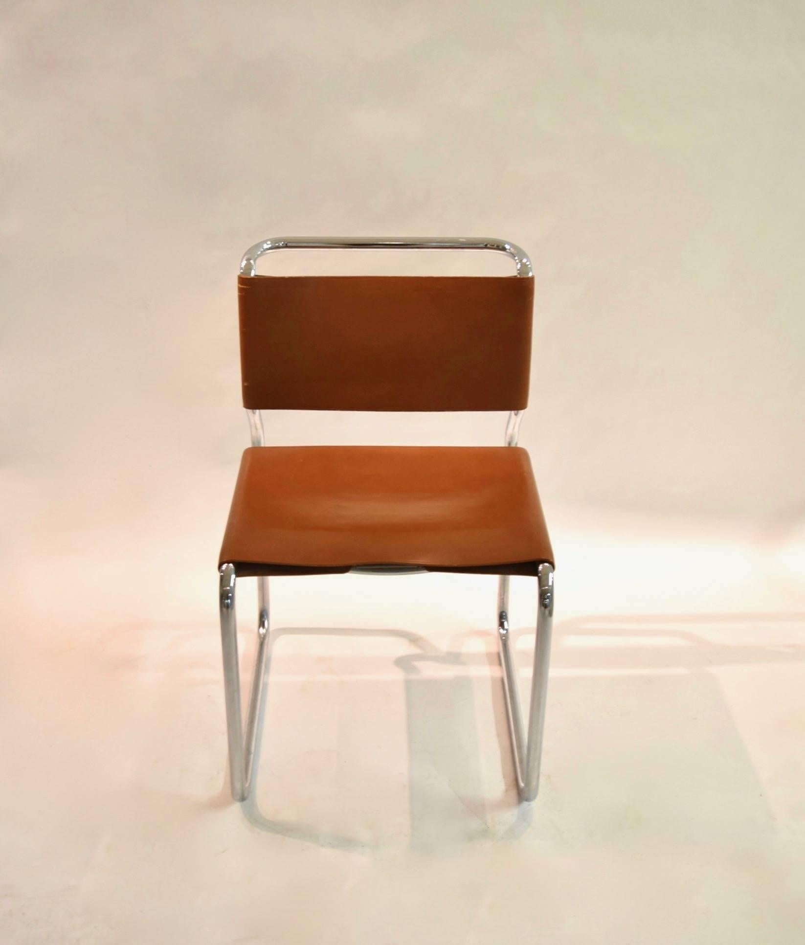 Six armless tubular steel side or dining chairs in excellent, original condition with light brown leather stretched as the seats and back rests; designed in 1966 by Nicos Zographos for The General Fireproofing Company.