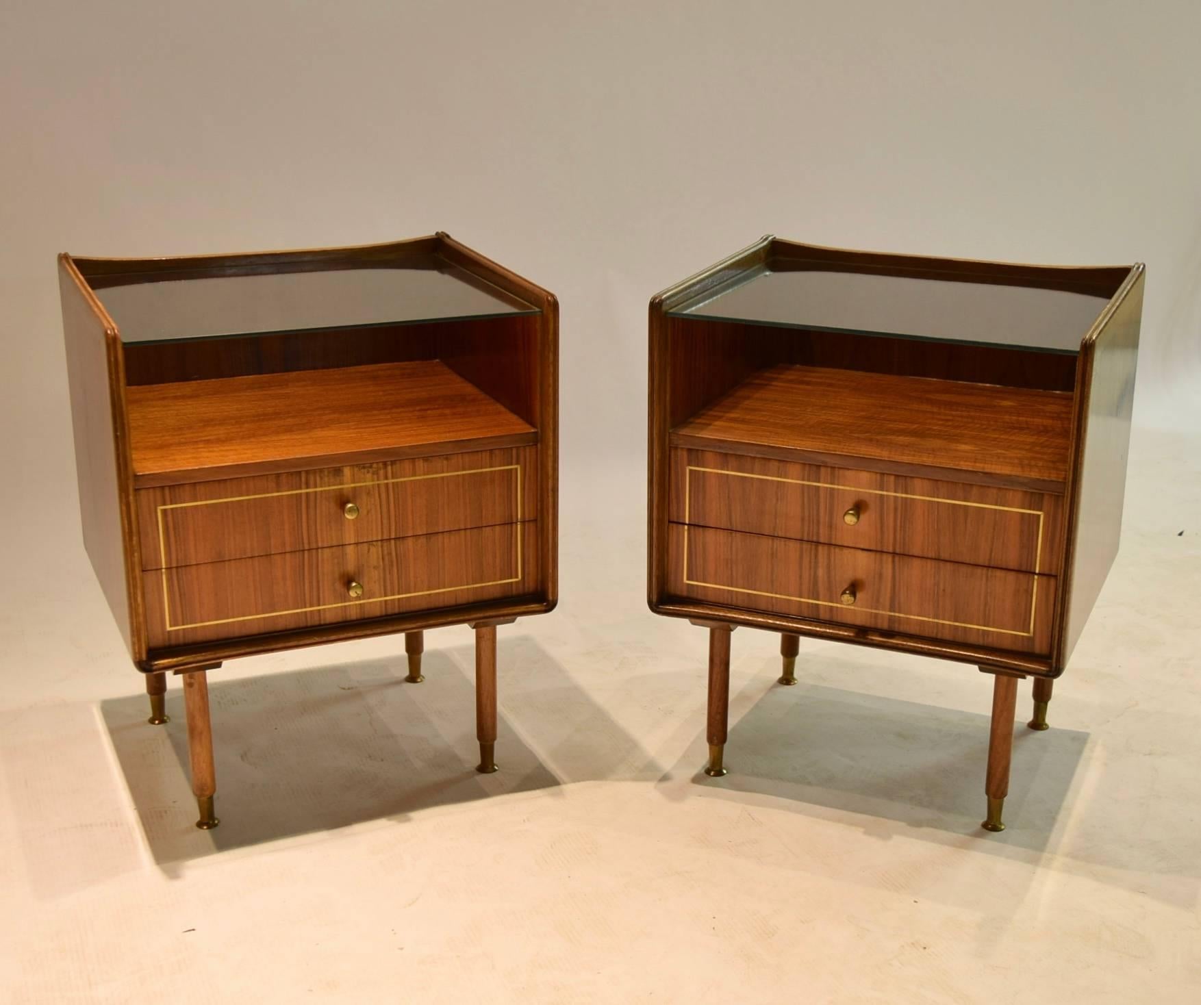 Pair of two-drawer, two-toned gloss finished wooden night stands / night tables each with brass pulls, linear, inset brass accents on the pull-out drawers, teal paper lining with a white atomic print, a clear glass top allowing for a top shelf and