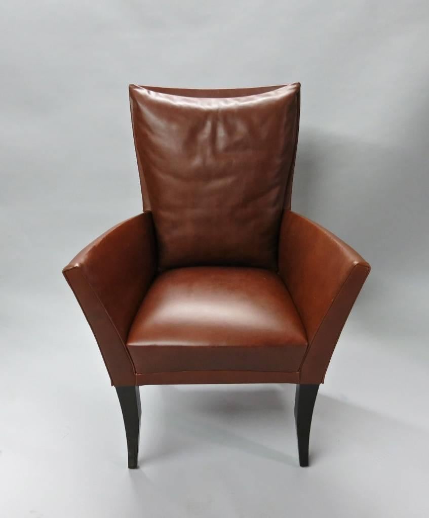 Four Dakota Jackson dining or side armchairs upholstered in their original brown-red leather and supported on four dark stained cherrywood legs. Each backrest has an attached pillow, and the original labels are intact and located on the underside of