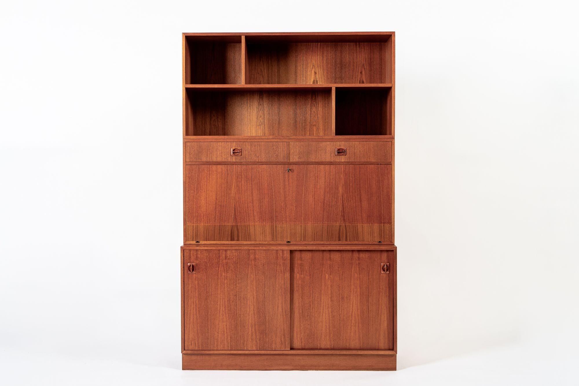 Questa scrivania e libreria alta in legno di teak vintage della metà del secolo scorso è stata realizzata in Danimarca intorno al 1960 e presenta un formato unico con una superficie di scrittura a ribalta che trasforma l'armadio a muro in una