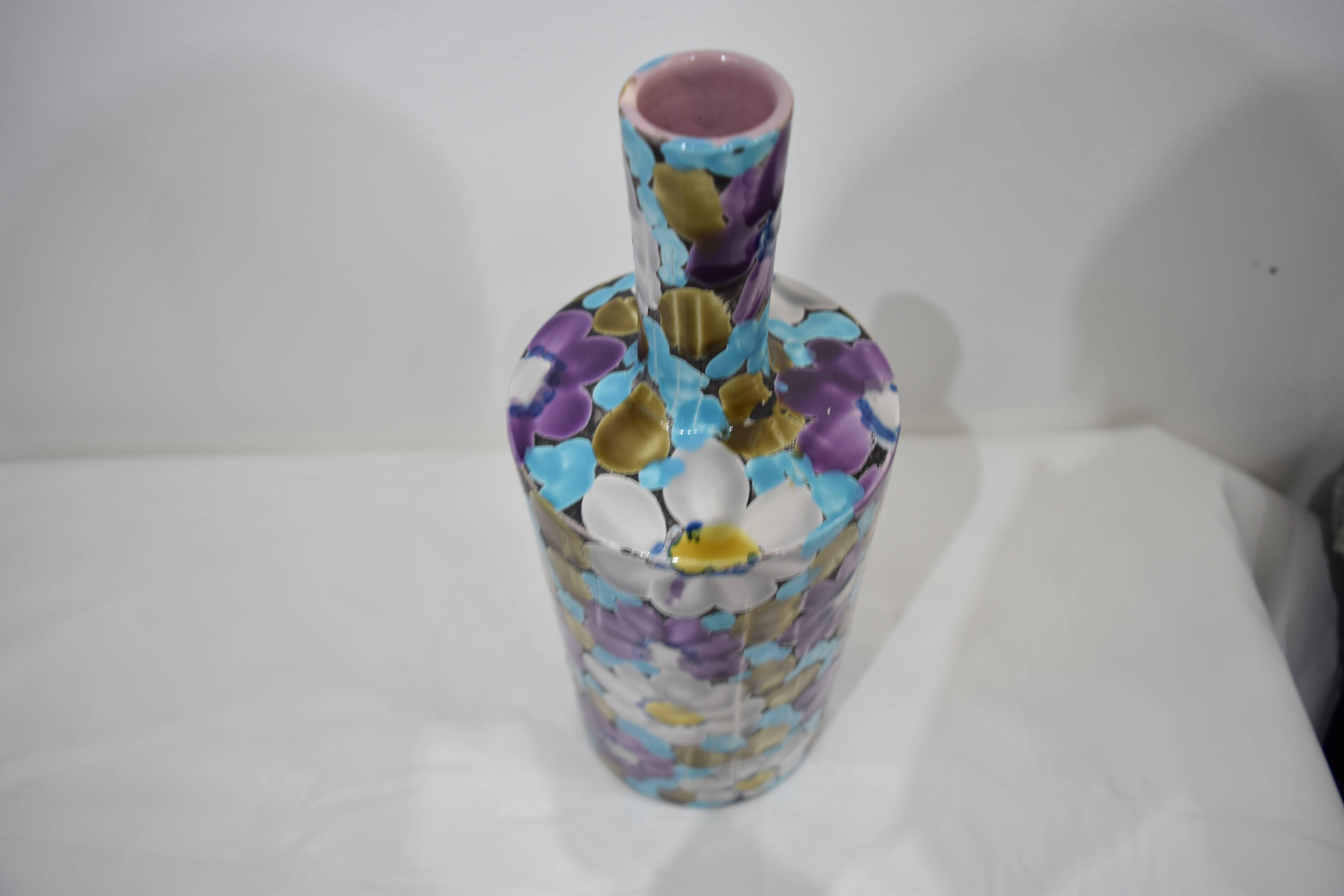 An Italian ceramic vase with floral pattern, handmade/painted in rich violet and teal hues.