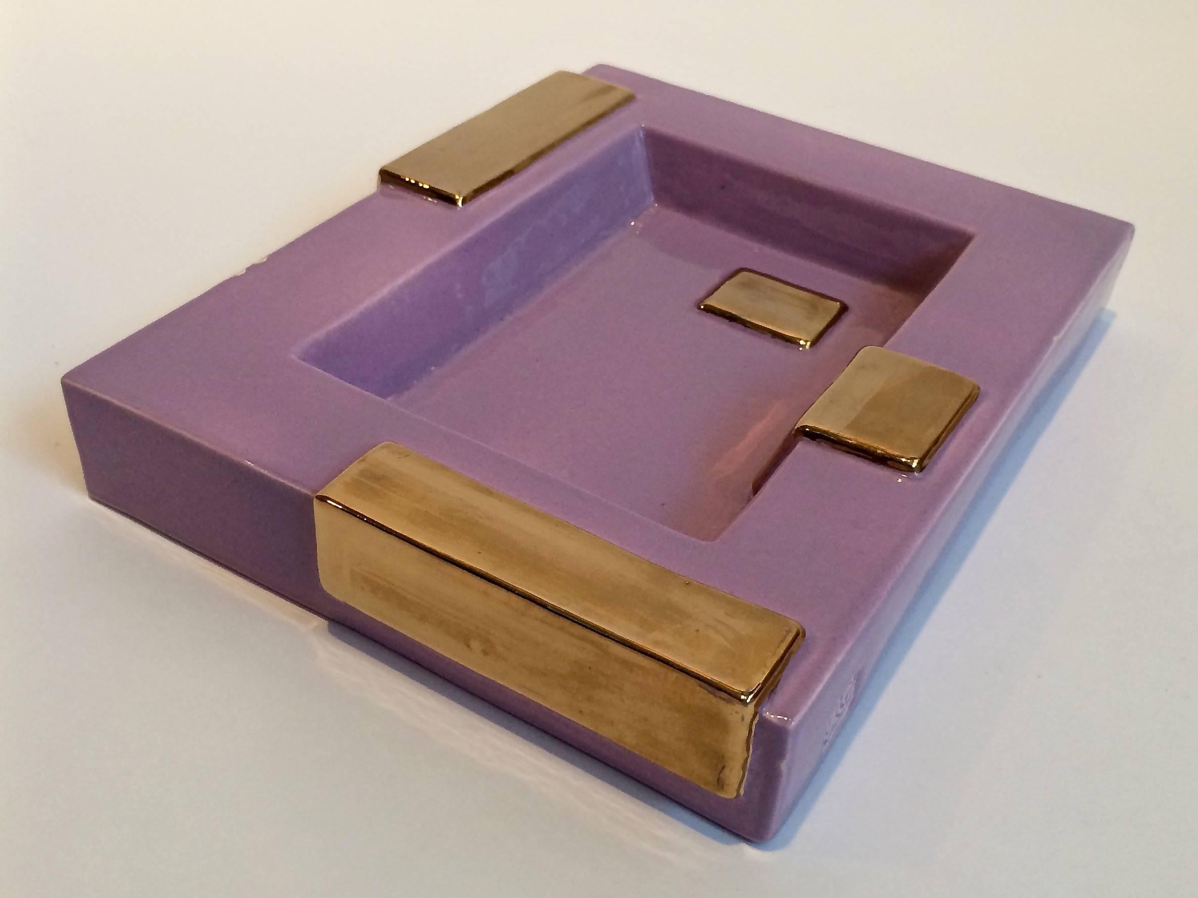 A lavender and gold ceramic tray by artists Elizabeth Garouste and Mattia Bonetti. The tray is part of the Boogie-Woogie collection which includes other ceramic table accessories. This piece is marked 