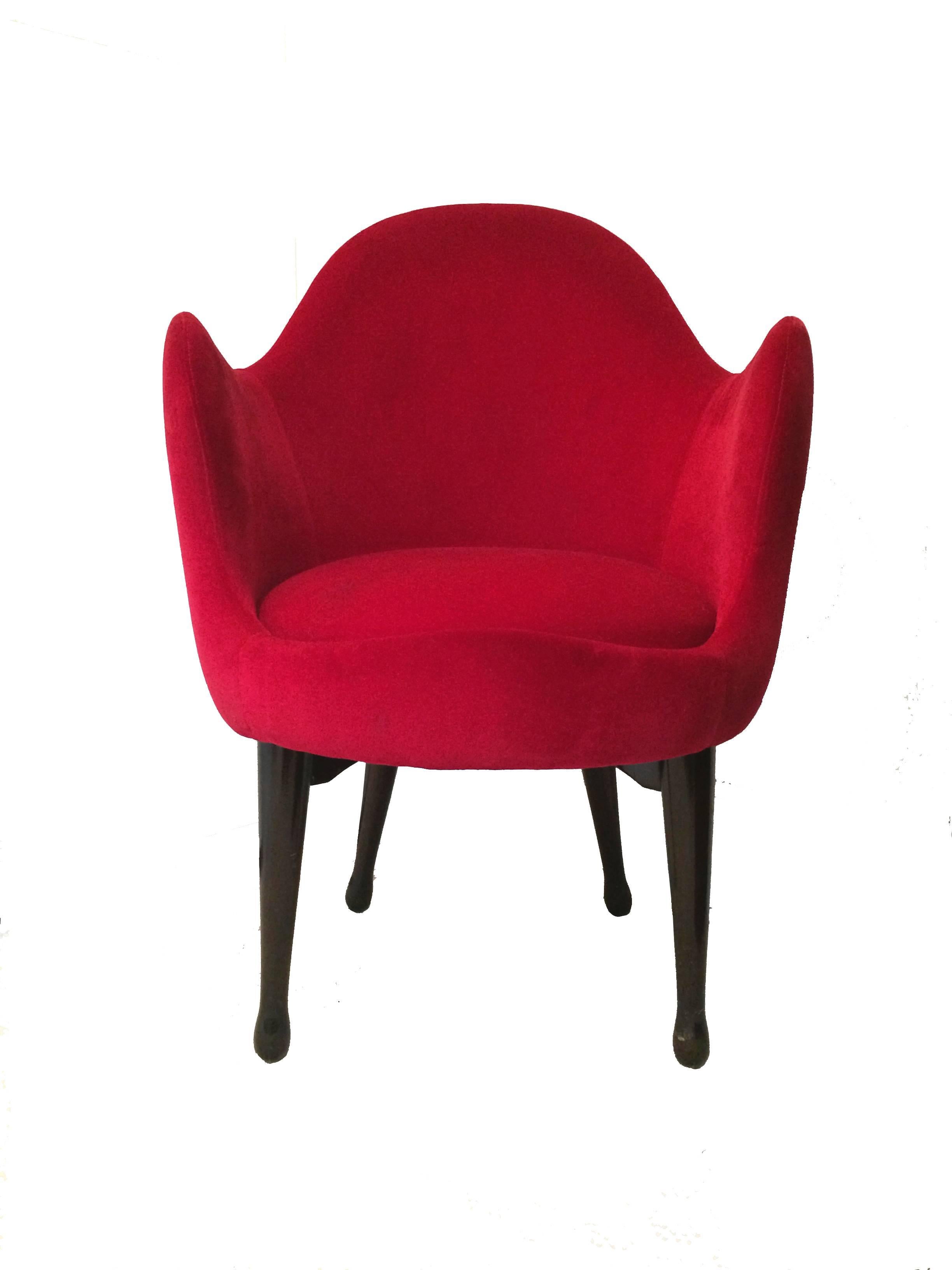 A club chair designed by Elizabeth Garouste and Mattia Bonetti with a curvaceous Silhouette upholstered in a red velvet sitting on tapered wood legs. 
The chair was designed for an Avenue Montaigne store during the height of their work in the