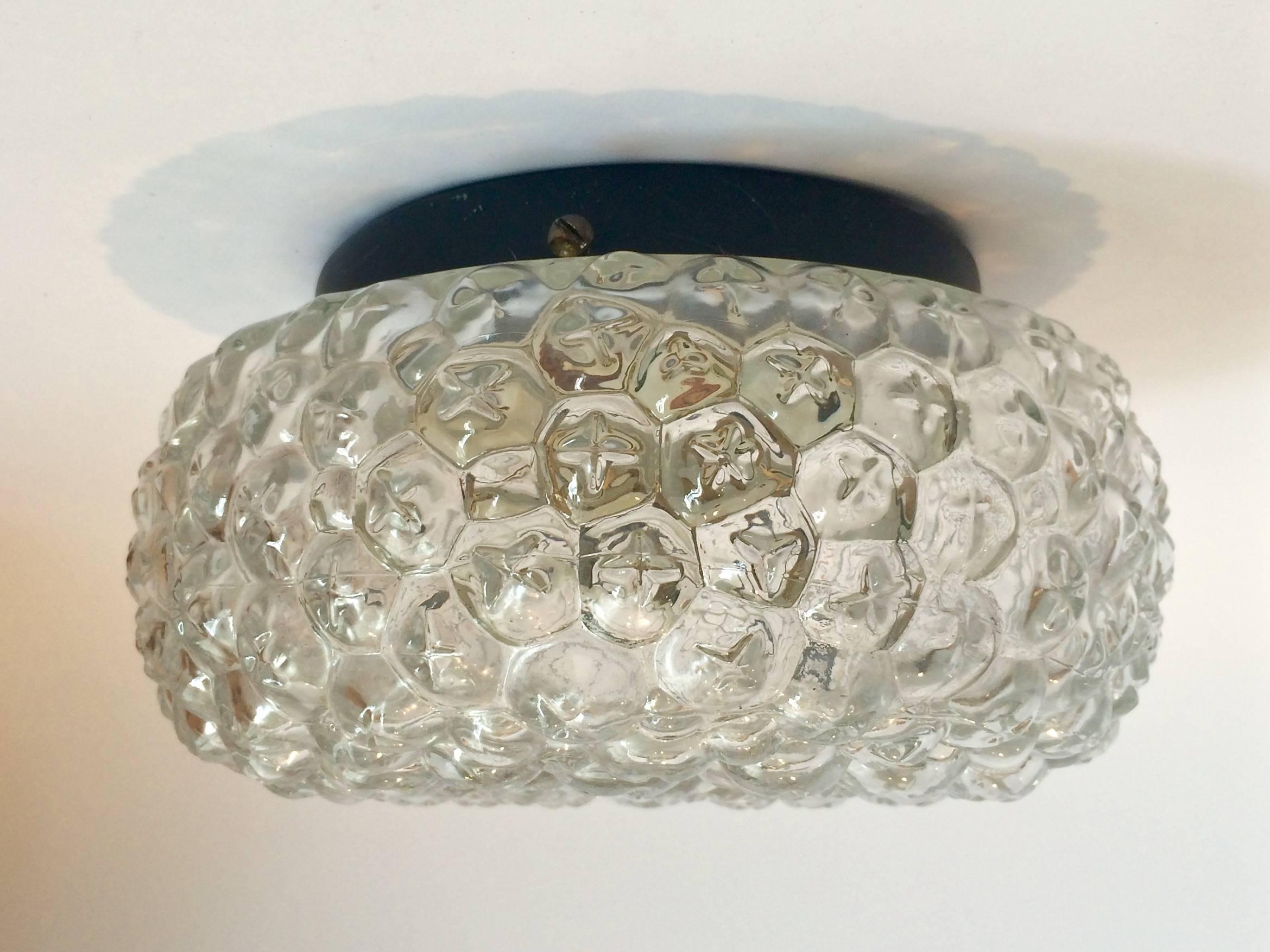 A bubble glass fixture that refracts light beautifully with a simple black metal mounting base in the manner of Helena Tynell. Can be mounted to the ceiling or the wall. Takes one 60 Watt bulb.