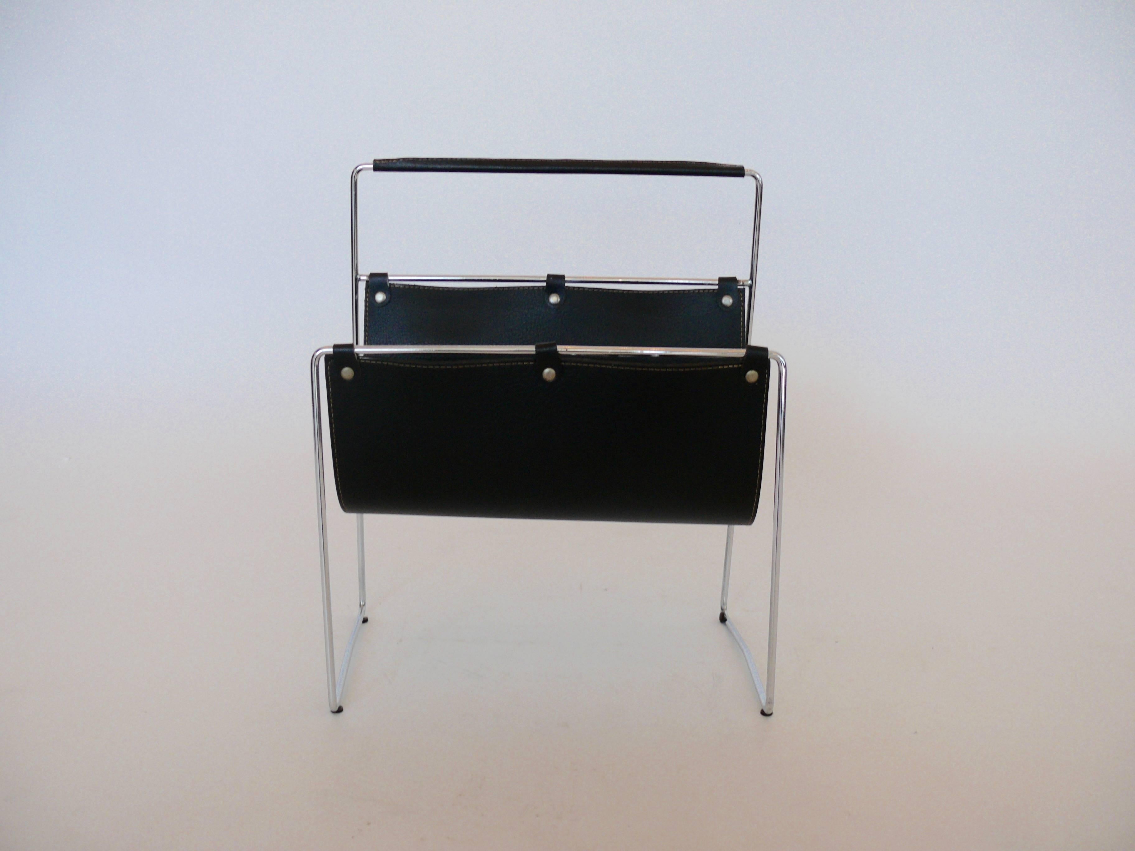 Simple French magazine rack with black leather sling and chrome. Classic Adnet style stitch to leather, with chrome rivets and leather loop detail attaching the sling to the frame. Excellent vintage condition.