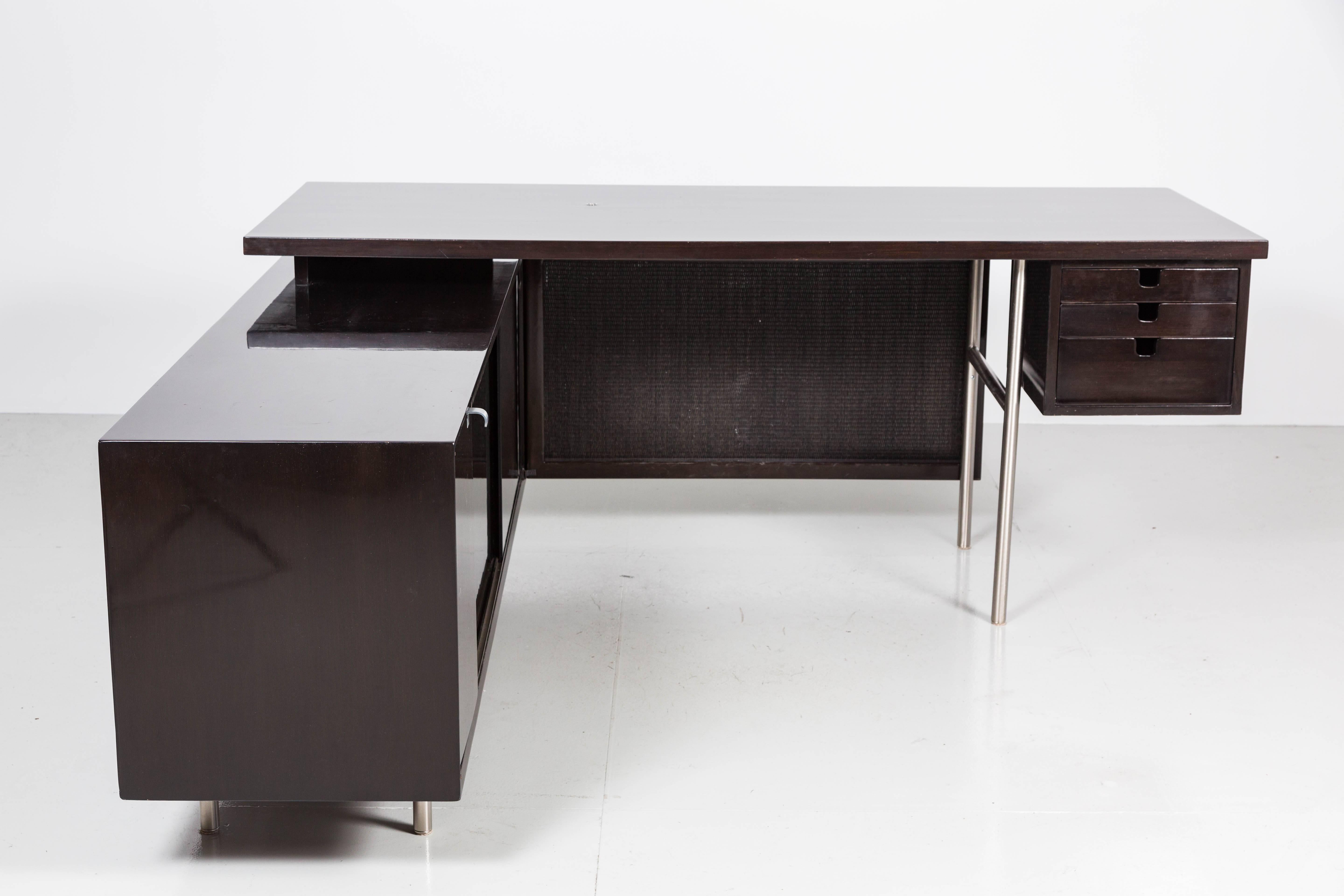 Handsome George Nelson for Herman Miller walnut desk with floating top, aluminum legs and caned modesty panel. Credenza return has ample storage including two interior shelves, two pull-out drawers and one cabinet.
Newly re-finished in ebony finish