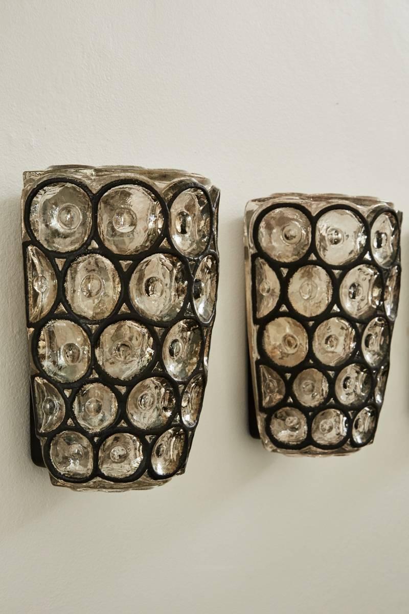 Impressive pair of German iron and glass flush sconces by Limburg. Glass framed by circular iron in a geometric pattern. Newly rewired and illuminates beautifully.