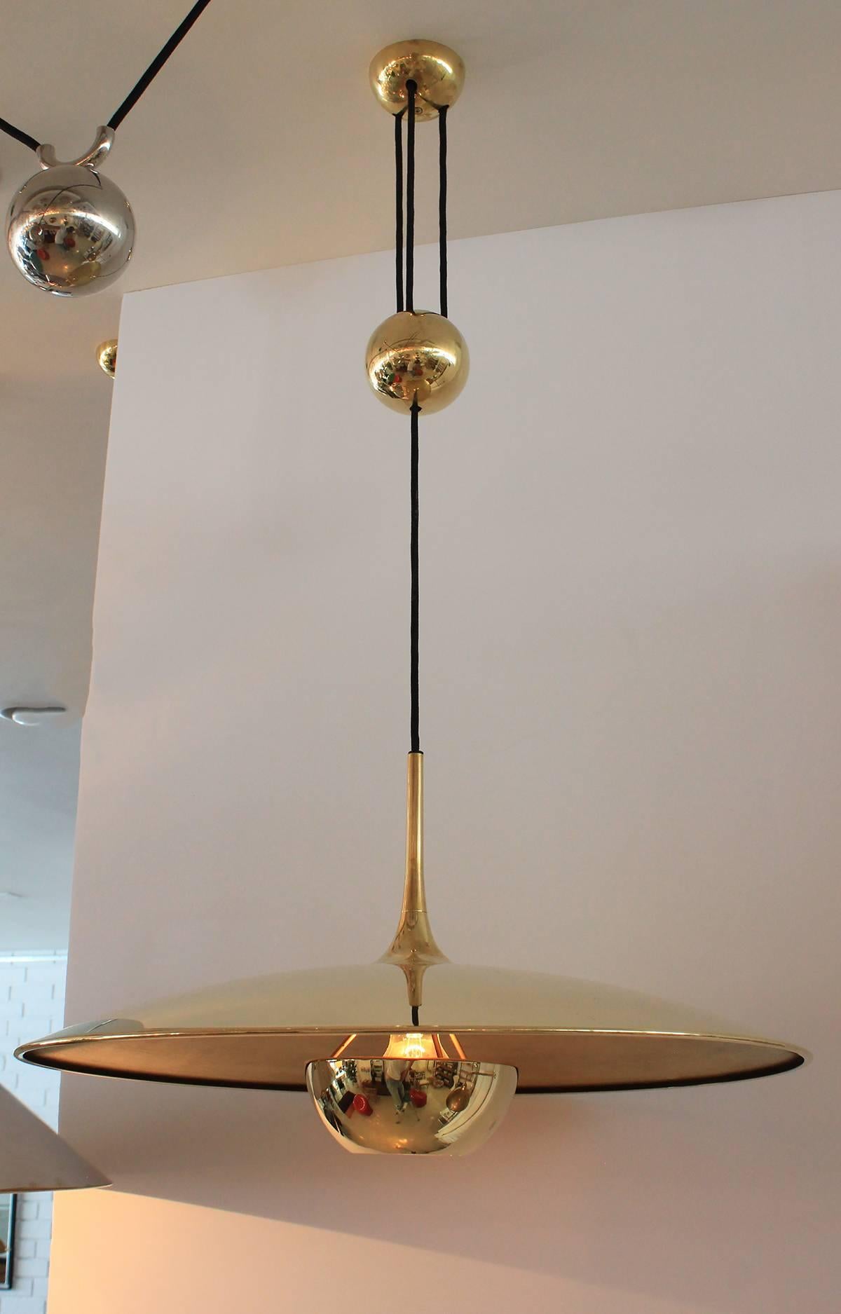 Brass counter balance pendant by German lighting manufacturer Florian Schulz. Heavy brass ball counter-weight and brass disc. Cloth cord. Great patina to brass. Excellent vintage condition. Height is adjustable.