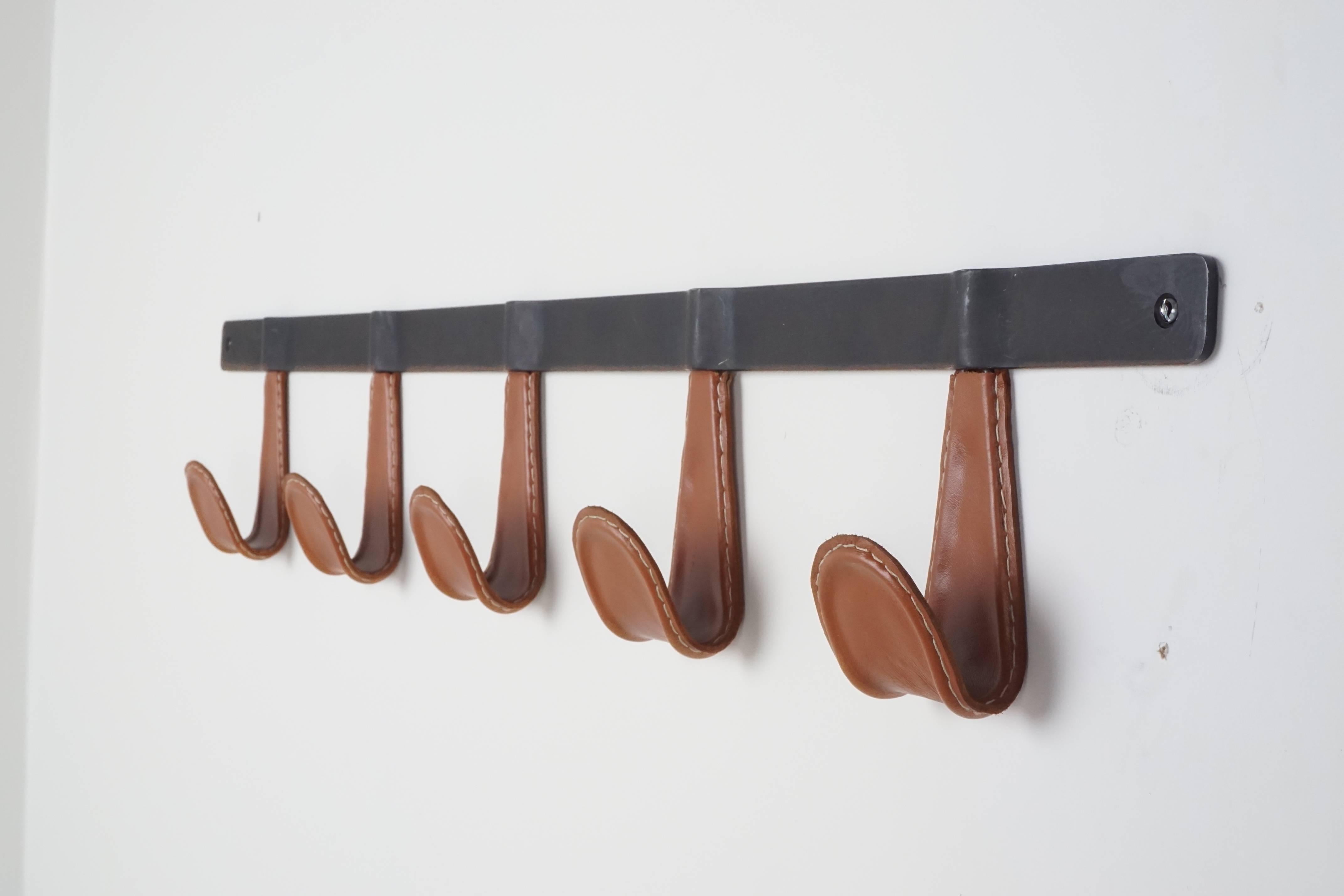 Five hooks wrapped in leather with contrast stitching. Newly produced by Orange Furniture and available in; cognac (shown) chocolate, black and COL.
