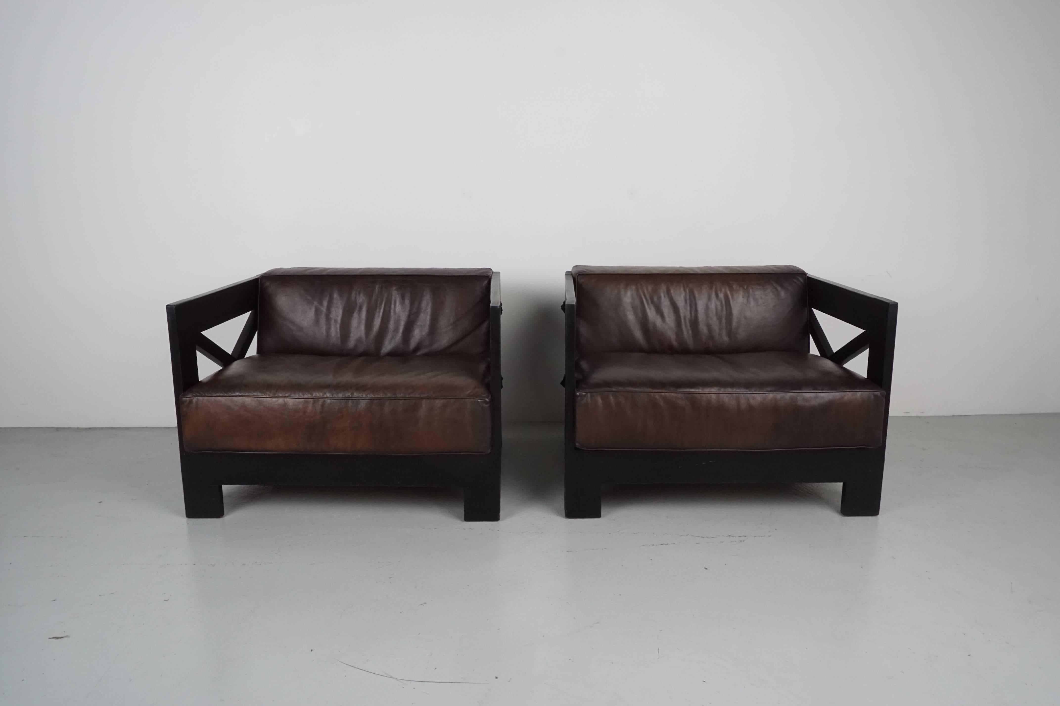 Pair of Jacques Adnet leather frame chairs. Black leather wrapped frames with espresso brown leather cushions. 