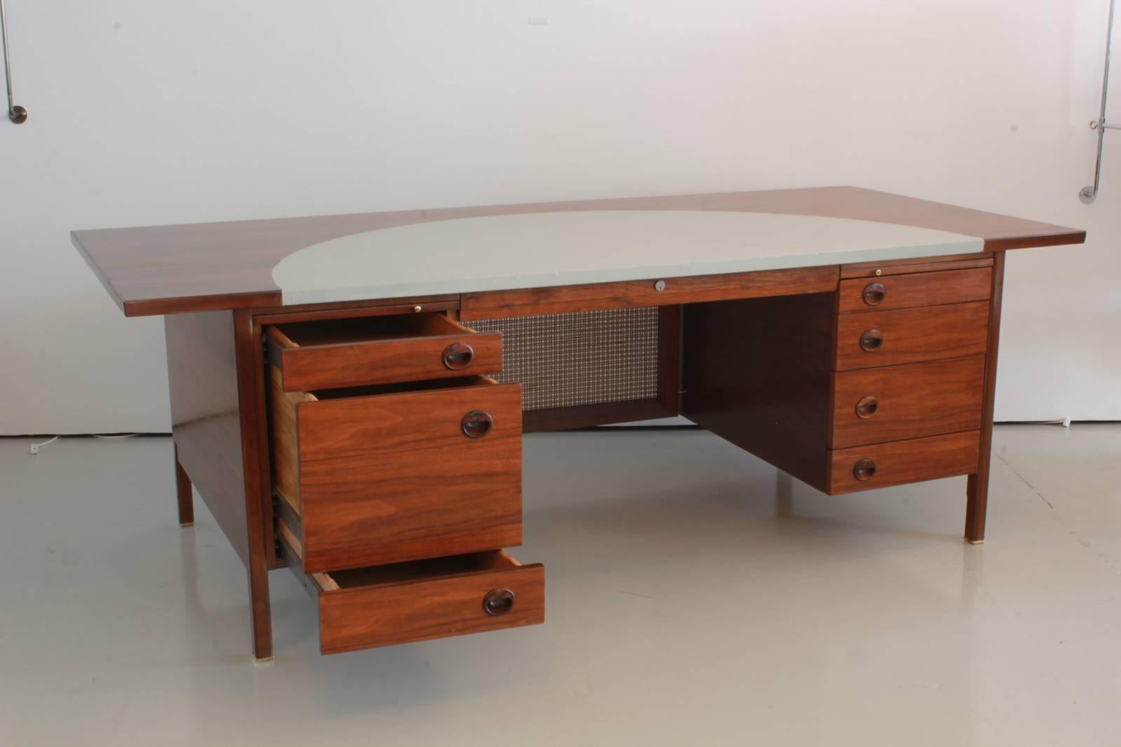 Edward Wormley design executive desk for Dunbar with grey leather inlay. Walnut desk with rosewood pulls and caned modesty panel.
Professionally refinished.