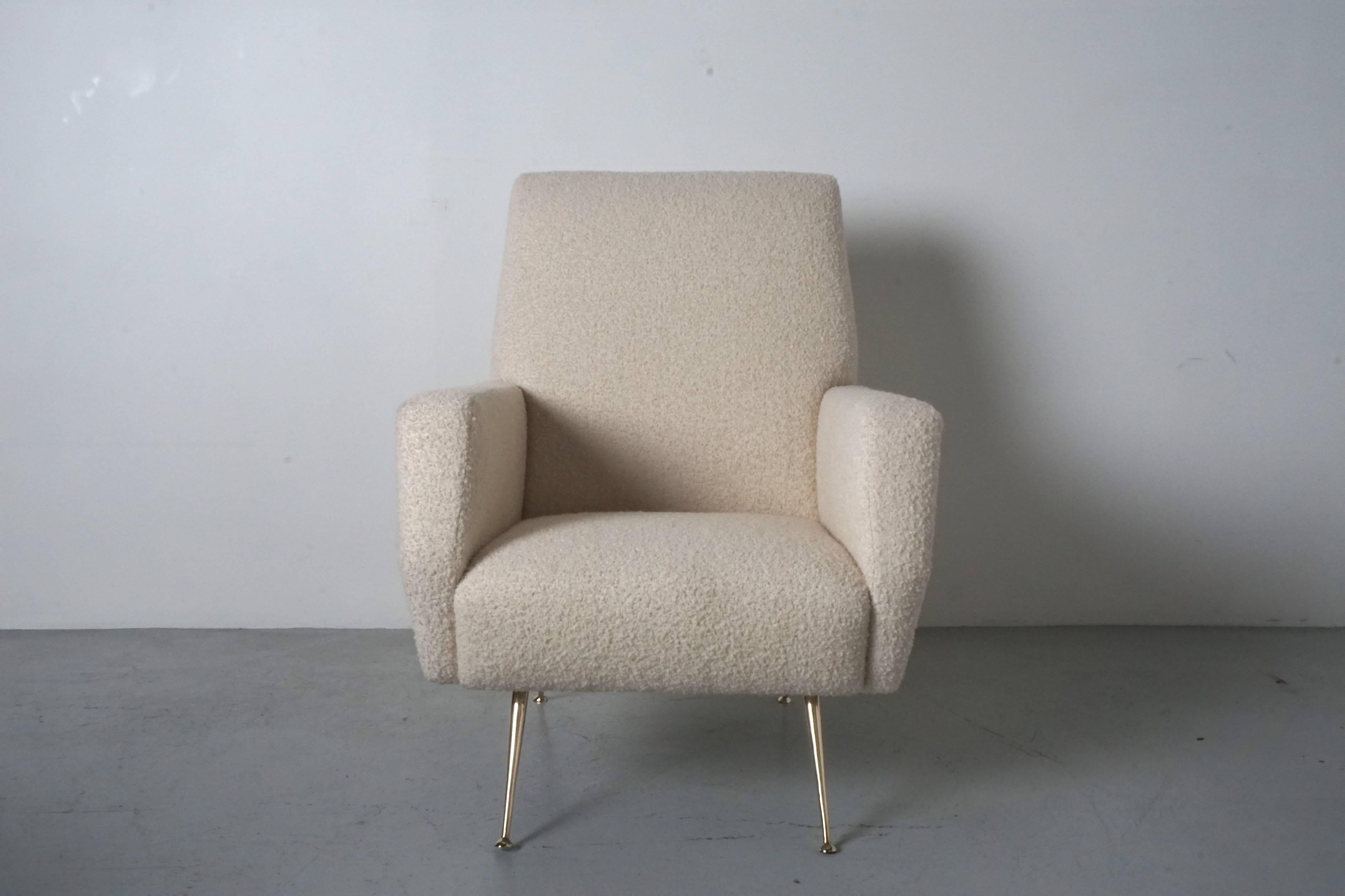 Pair of Italian armchairs with wonderful shape and angled arms. Newly reupholstered in a soft, creamy white wool bouclé́. Newly polished brass legs.