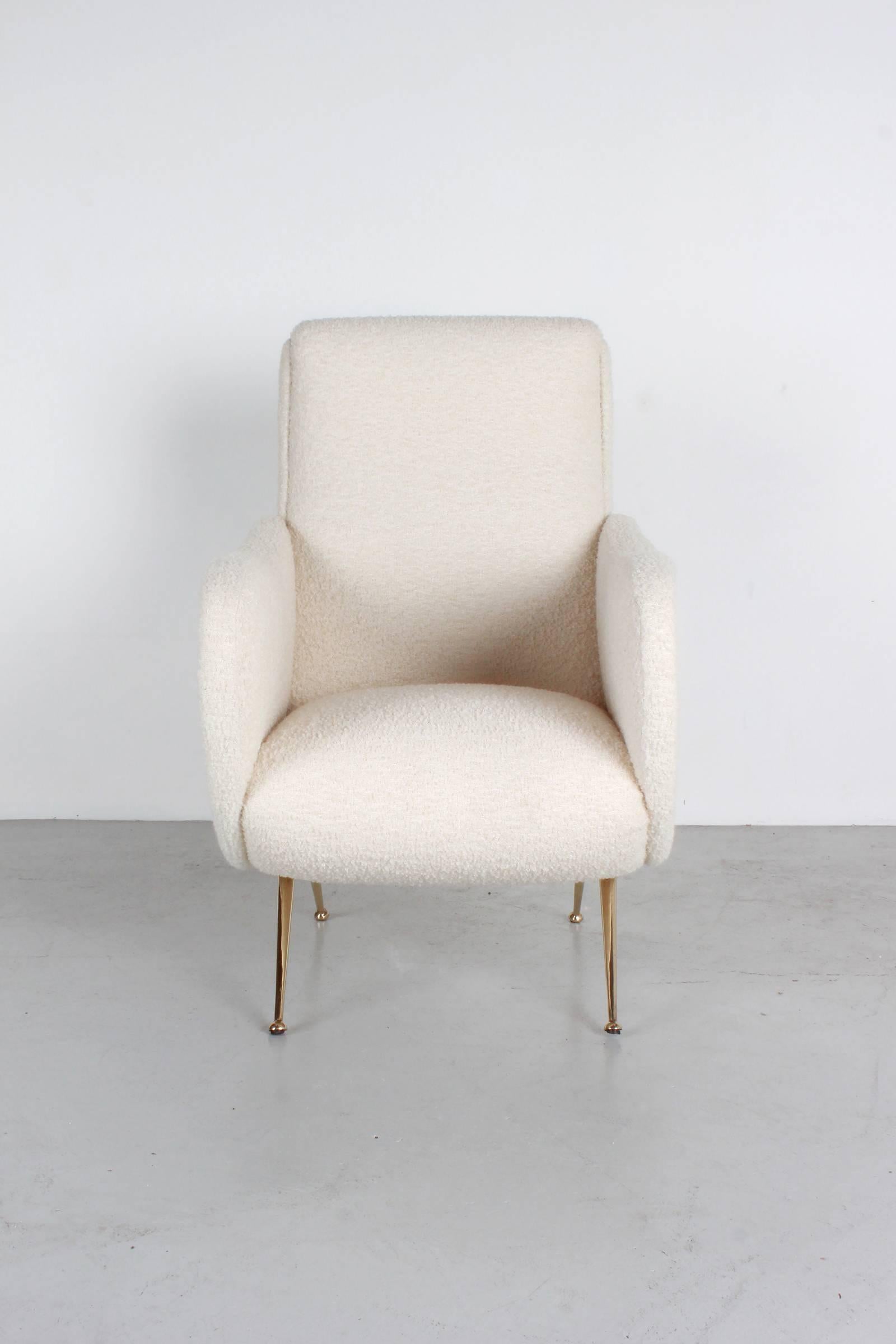 Pair of Italian club chairs in the style of Marco Zanuso upholstered in creamy white bouclé with newly polished brass tapered legs.