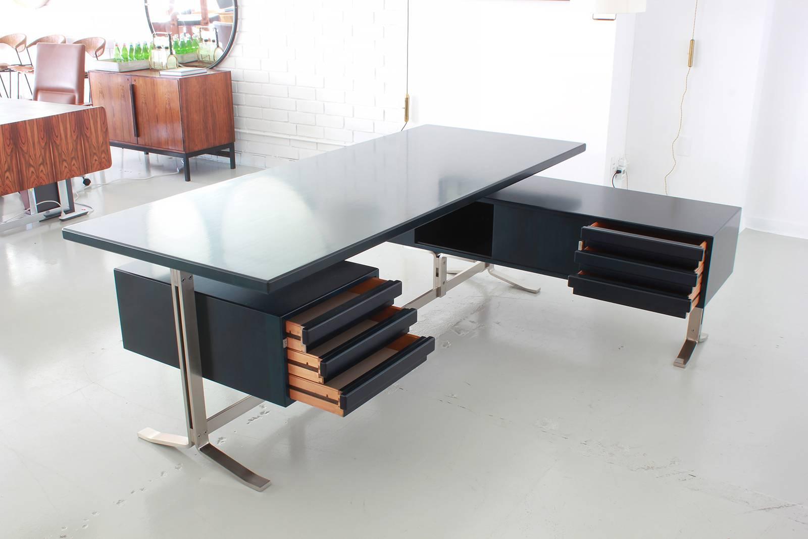 Handsome executive desk by Gianni Moscatelli for Forma Nova. Newly refinished in a dark ebony stain with polished finish. Desk surface rests on flat chromed steel legs with floating drawers on either side. Large work space and extremely impressive!