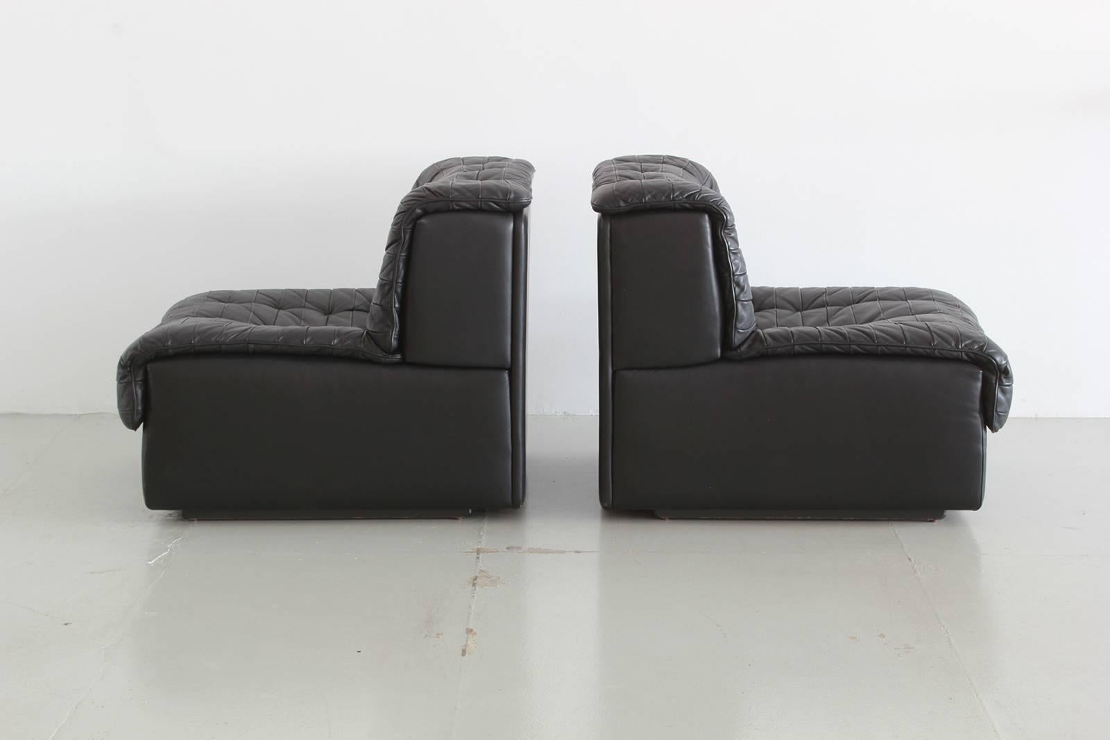 Tufted leather club chairs by De Sede in black leather.