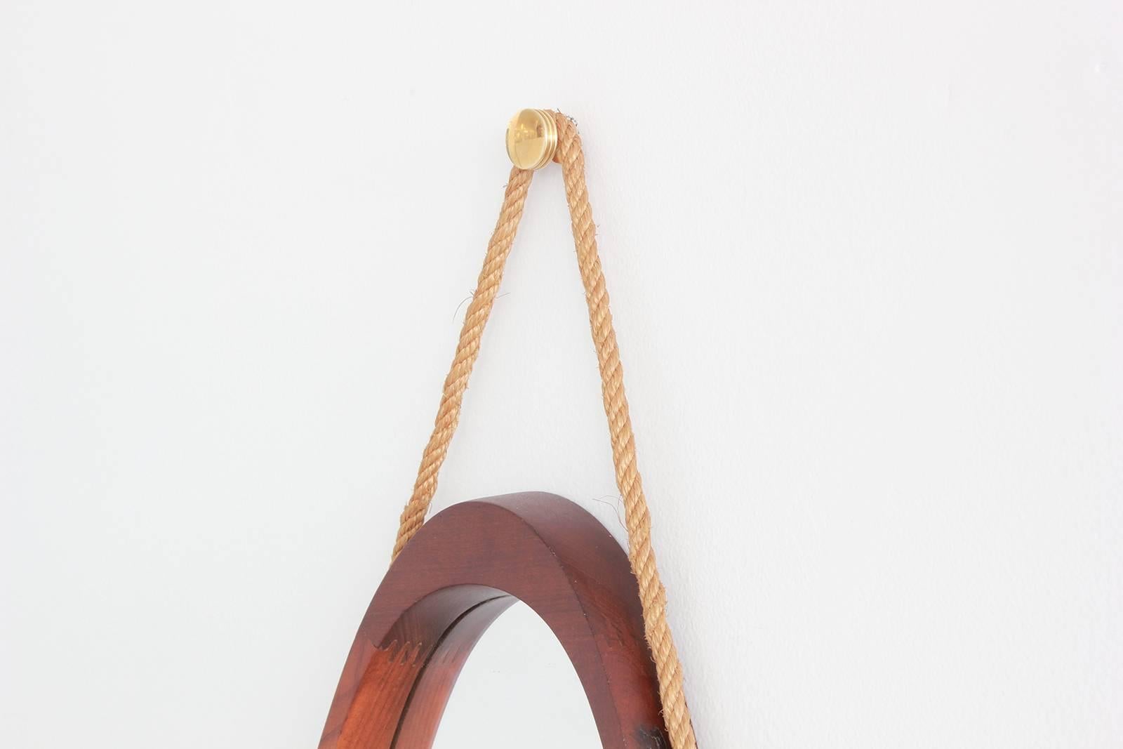Unique shaped Italian mirror made of teak with simple hardware and design. Beautiful details like green leather tassels at joints.

Perfect for hallway or foyer.

Measure: Overall height (including rope): 39.5