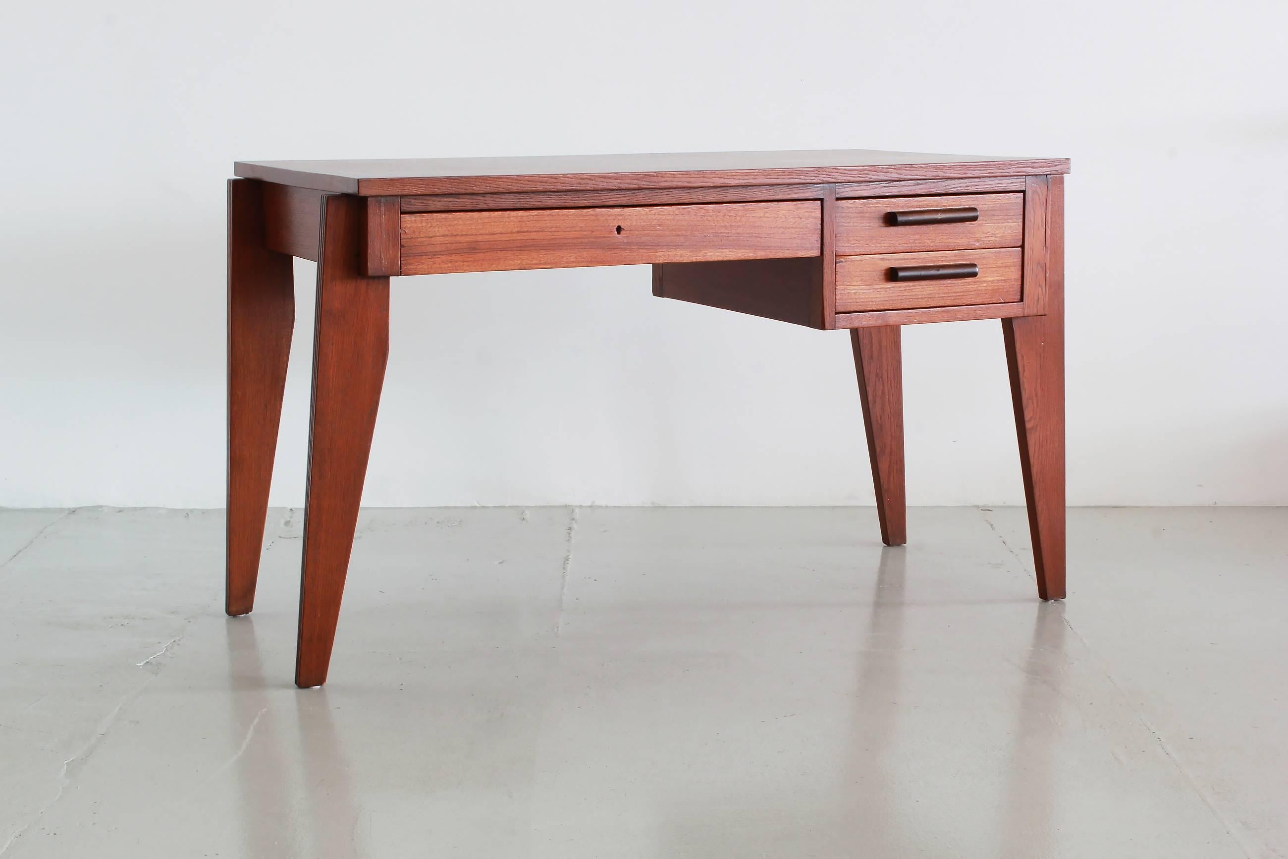 Wonderful desk by French designer Andre Sornay.
Warm French oak with contrasting wood handles on two drawers and pencil centre drawer.
Prouve style angled legs.
Fantastic piece!
    