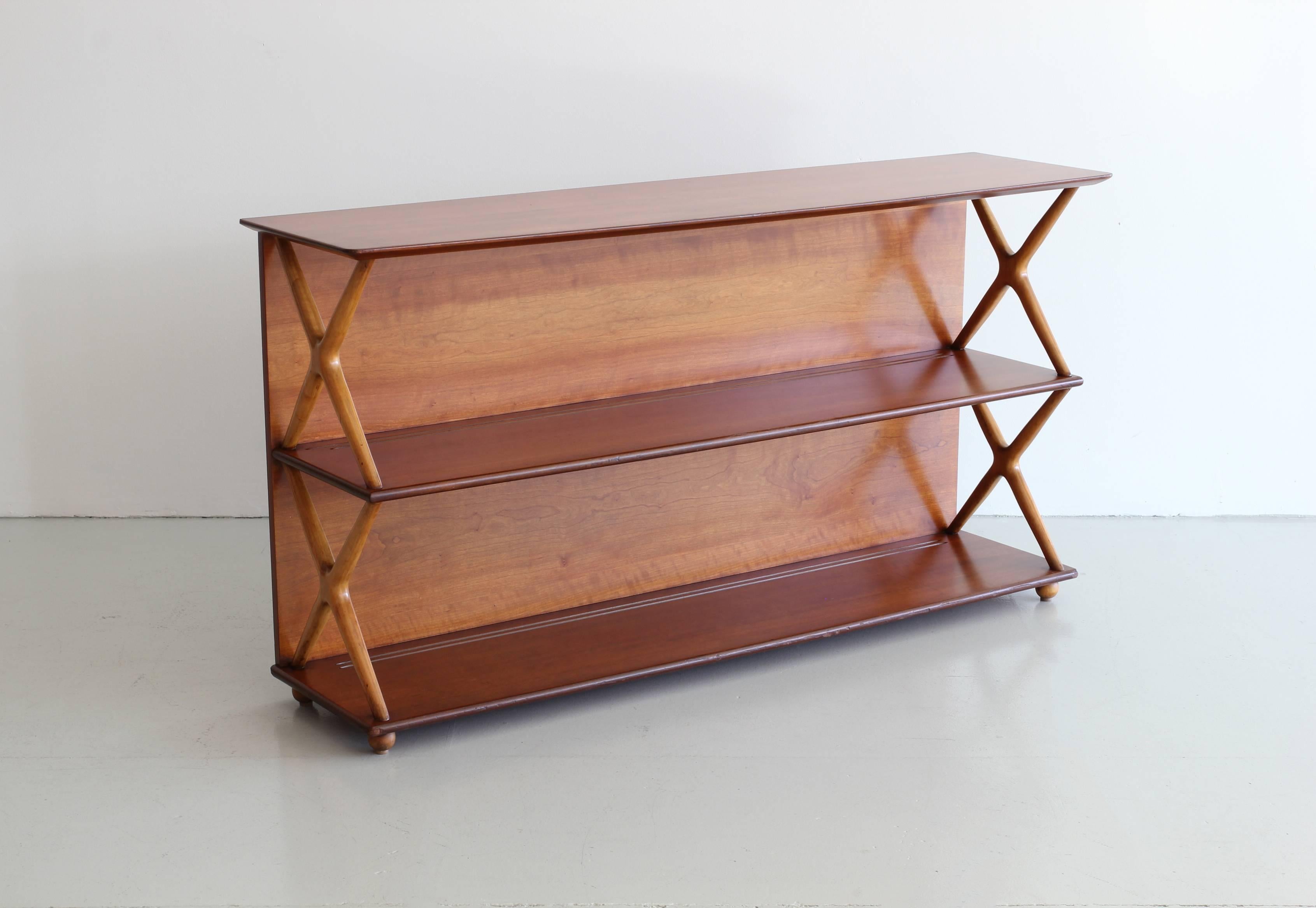Renzo Rutili bookcase for Johnson Furniture. Simple mahogany bookshelf with crosses sides in a slightly lighter color.
Wonderful original patina.
 
