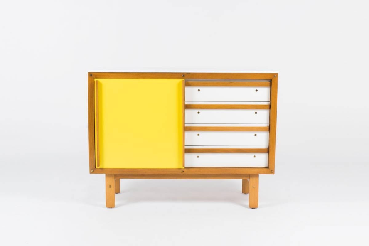 Rare dresser cabinet by French cabinetmaker Andre Sornay. Cabinet has pop of color yellow and oak with sliding door revealing drawers on one side and open shelving on the other.