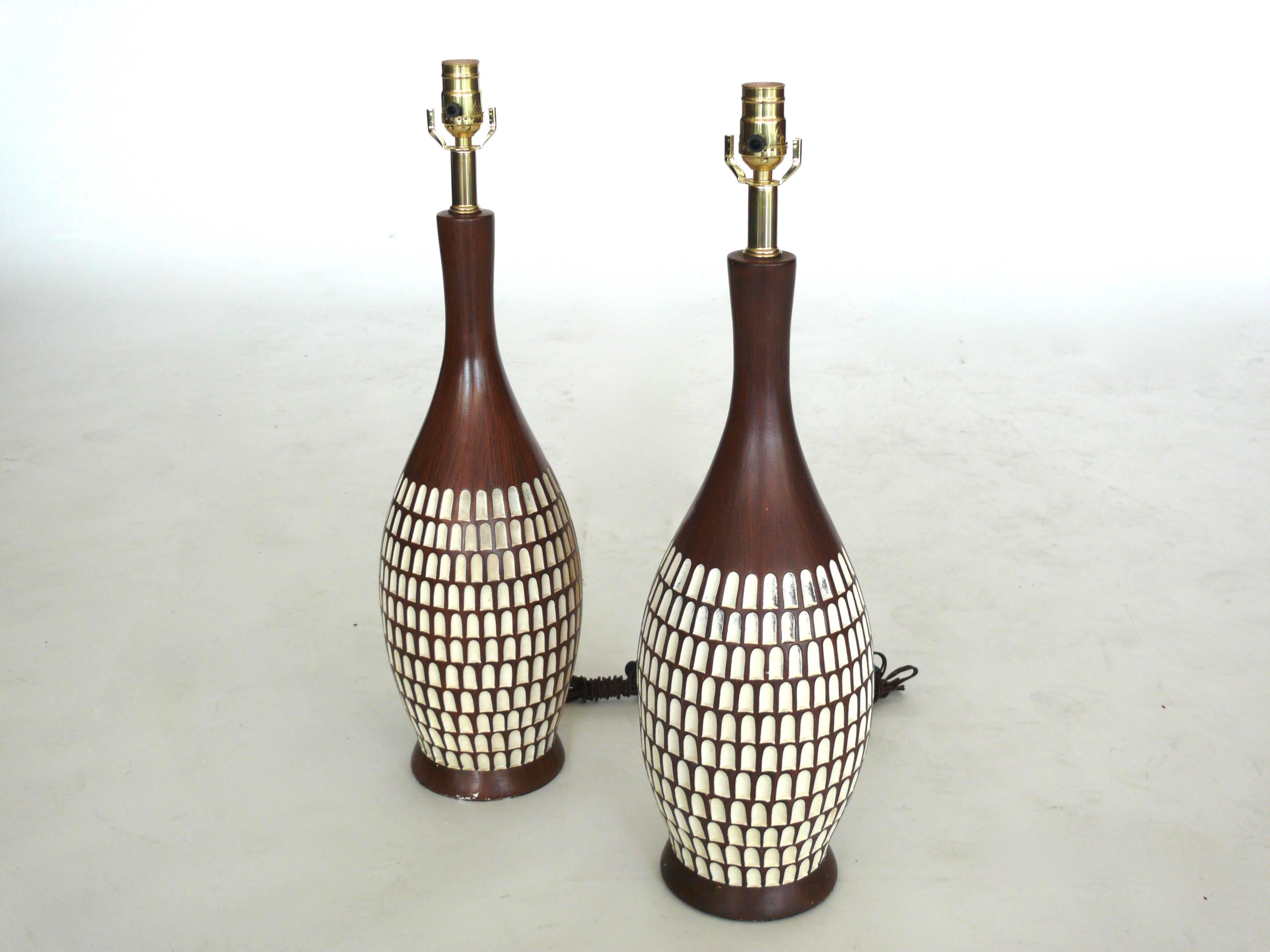 Great pair of fortune ceramic lamps in the appearance of teak but are actually entirely made of ceramic. Great bowling pin shape and newly rewired. 
Slight imperfections in the glaze indicative to its age.