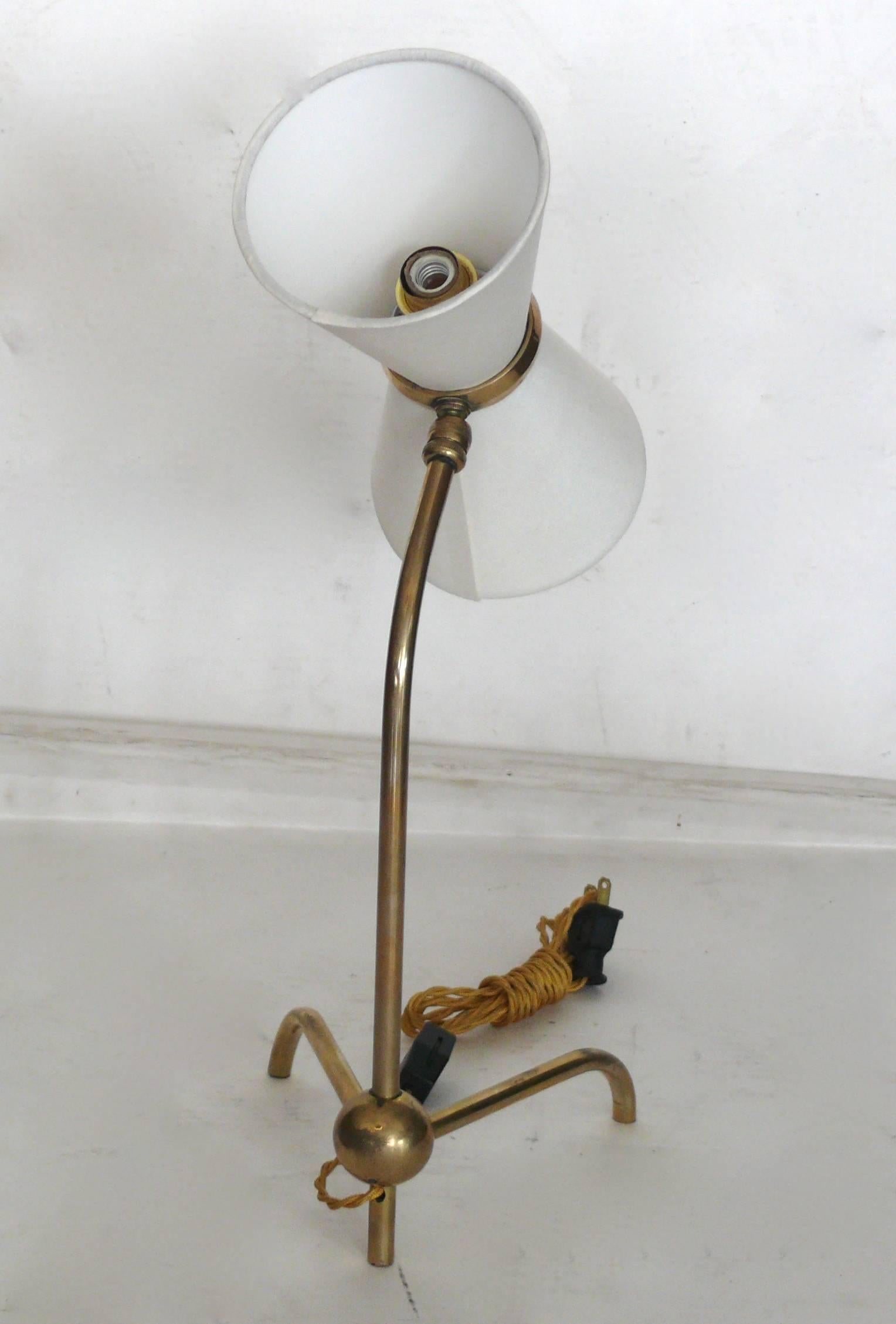 Classic French desk lamp in the style of Pierre Guariche. 
Brass tripod base and brass stem. Lamp features two sockets with up light and downlight. Newly re-wired. New silk shades.