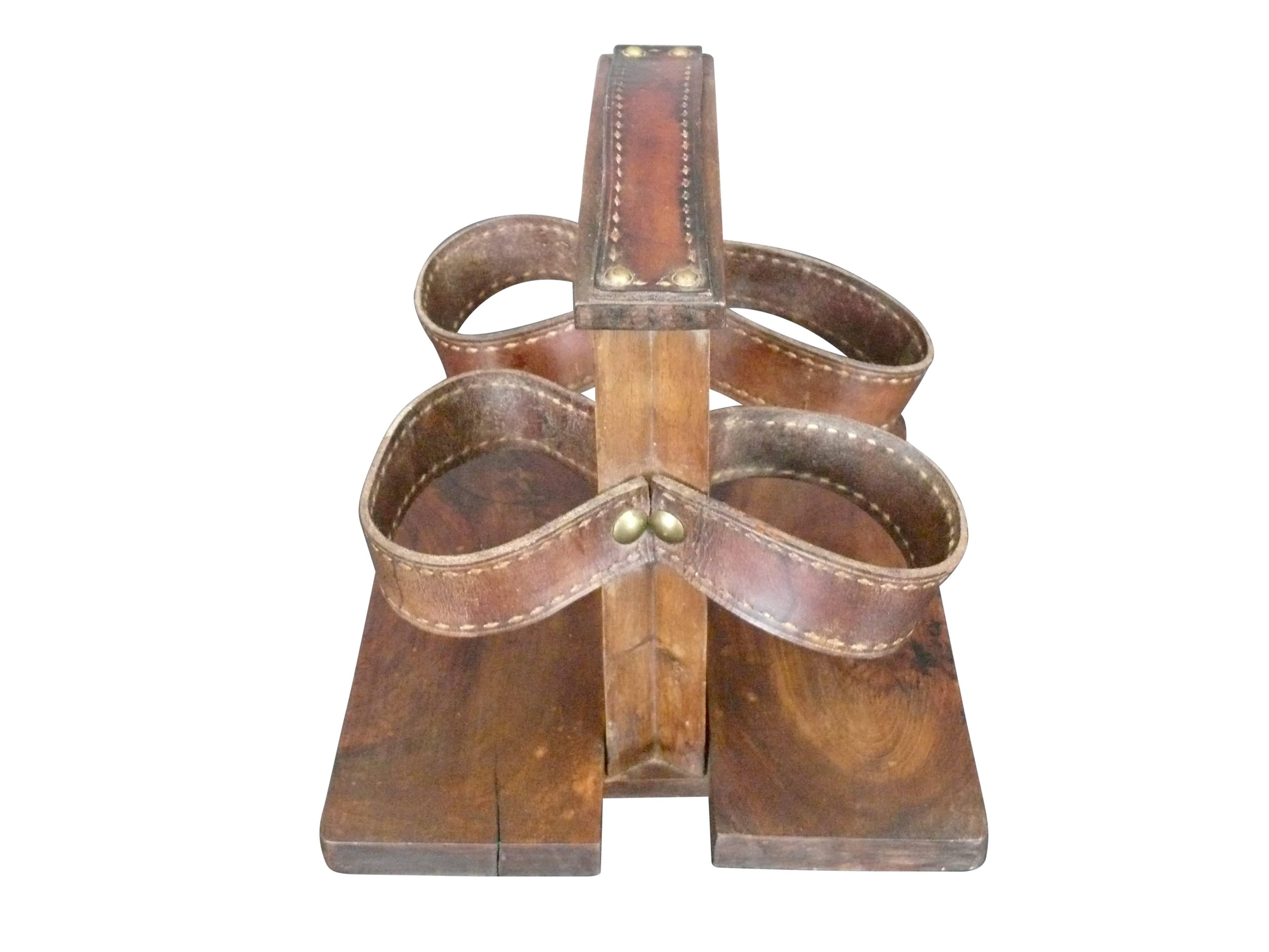 Handsome French tabletop wine holder in the style of Jacques Adnet. Oak base and frame with saddle leather details and straps. Complete with brass hardware and characteristic contrast stitch.
