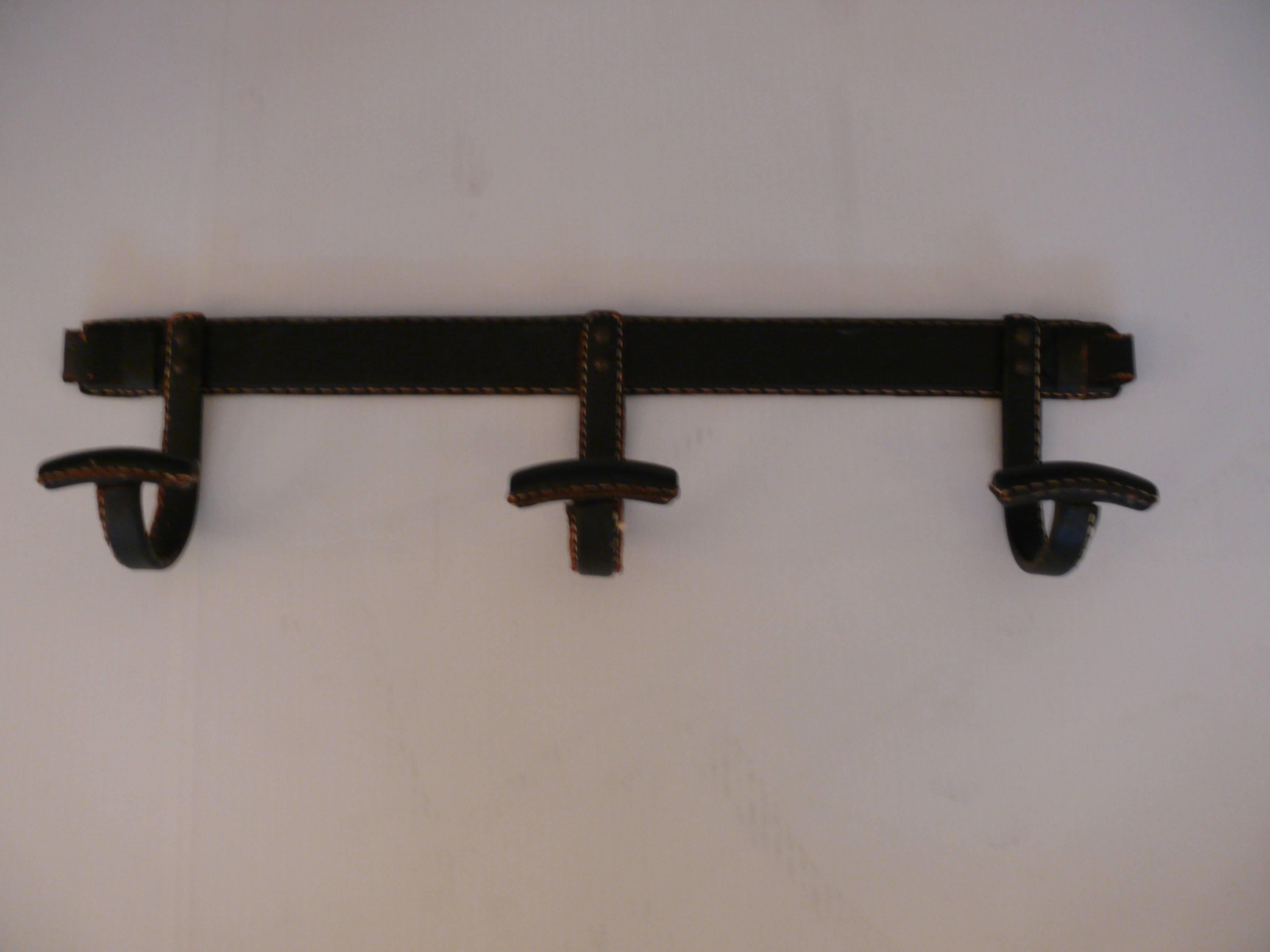 Handsome leather coat rack by Jacques Adnet. Black leather with contrast stitching on an iron frame. Excellent vintage condition.