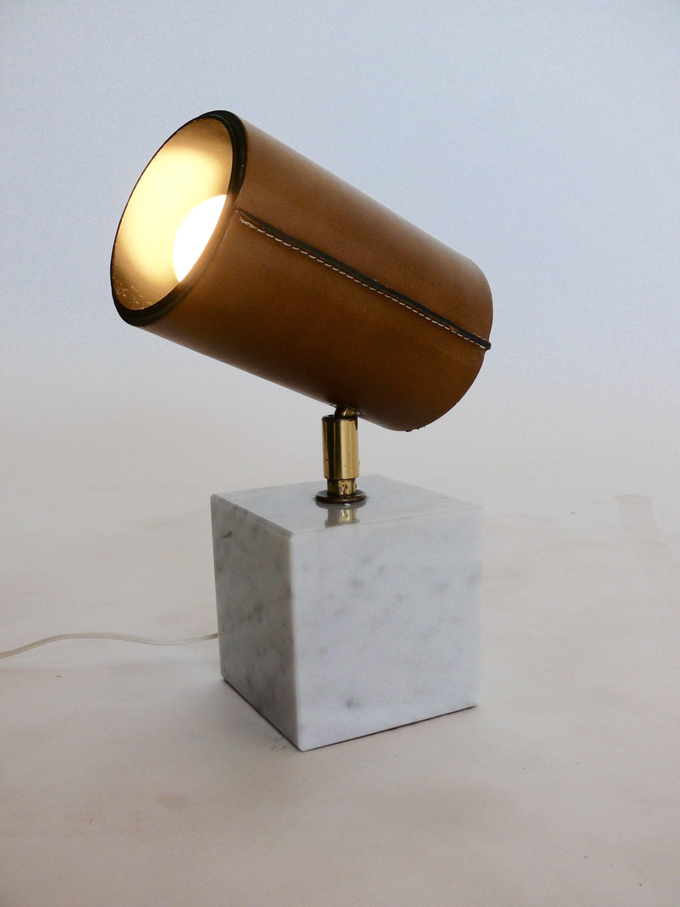 Wonderful petite Koch & Lowy desk lamp with marble and leather shade. Nice juxtaposition of Carrara marble cube, brass stem and leather shade with contrast stitching. 
The shade pivots to angle for desired lighting. Newly rewired, excellent vintage