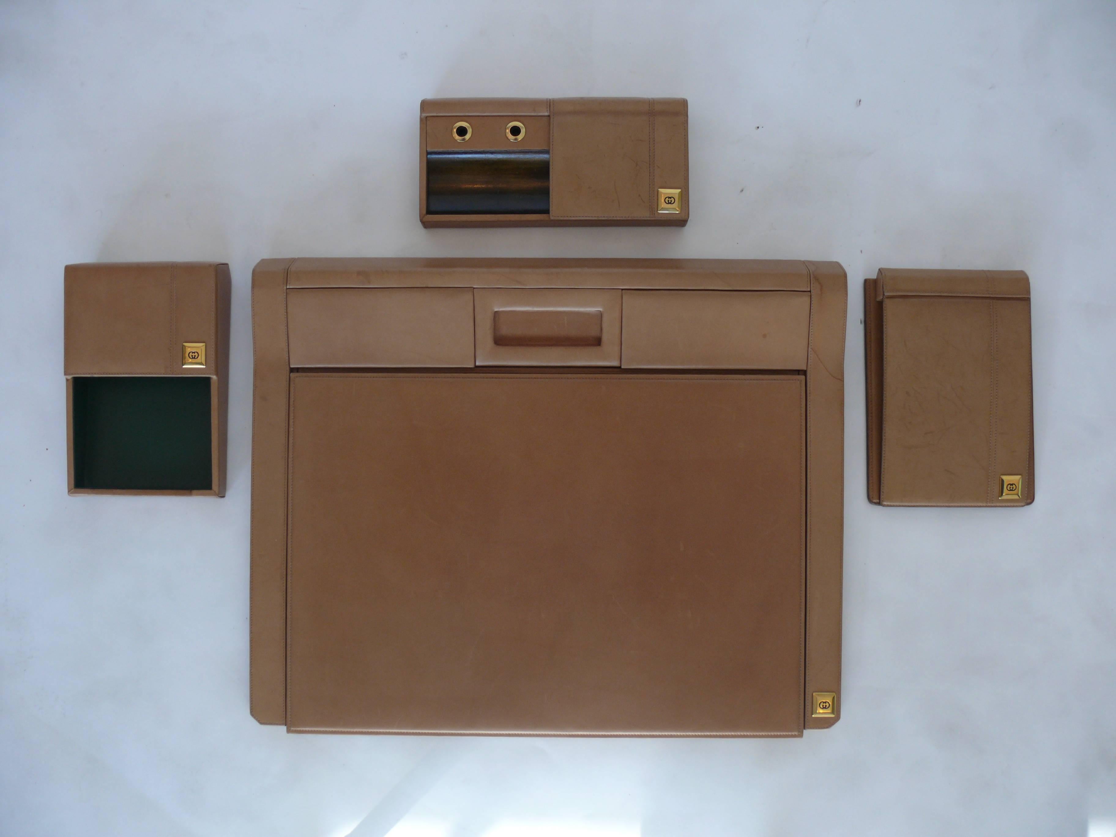 Incredible Gucci desk accessory collection. Set includes an ink blotter desk pad, note pad, letter holder and pen holder. Beautiful carmel colored brown leather with age and patina. Each item is embossed by the Gucci insignia. Stunning vintage set.
