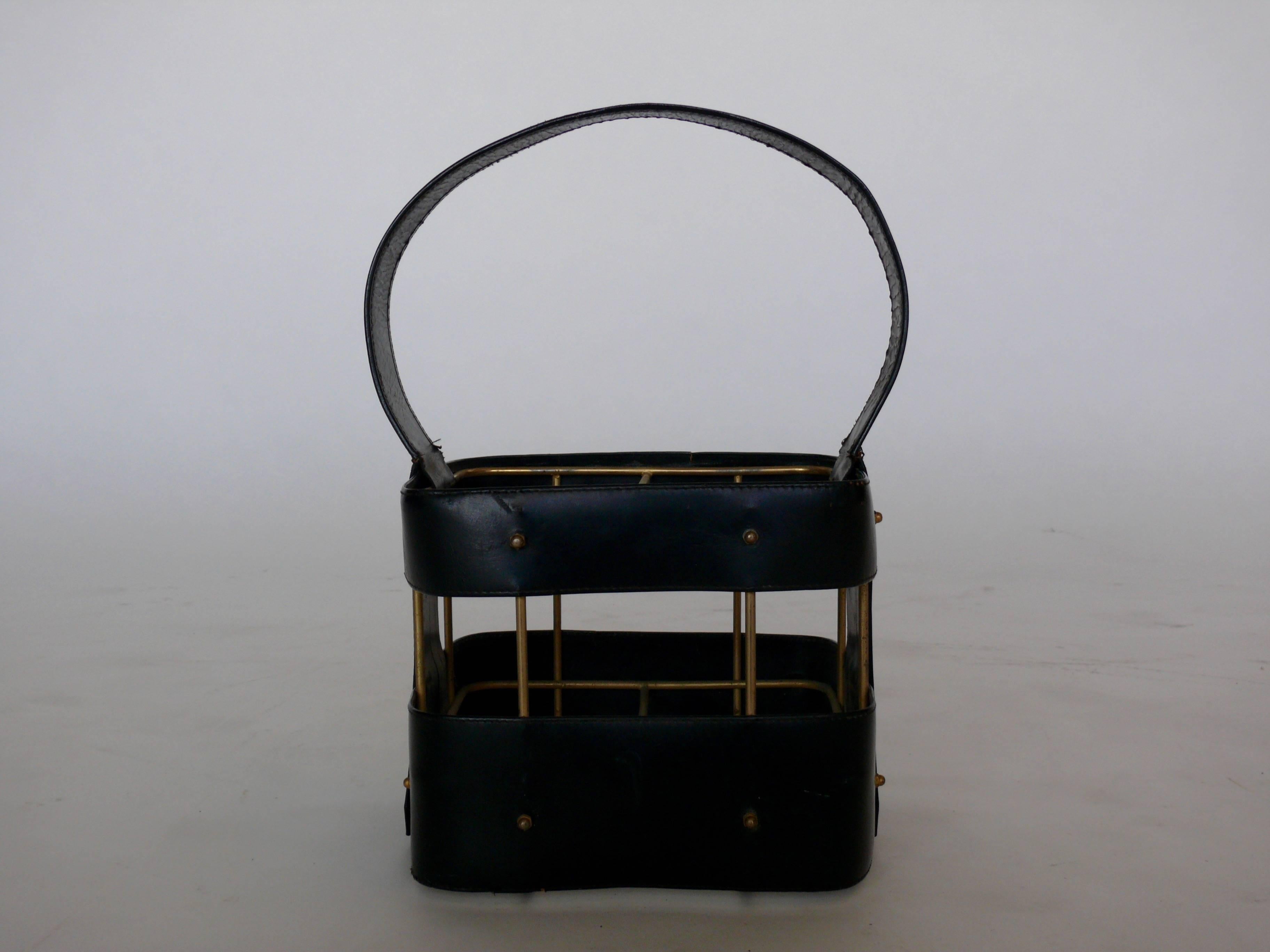 Handsome black leather Jacques Adnet wine holder. Holds four bottles with brass detailing.