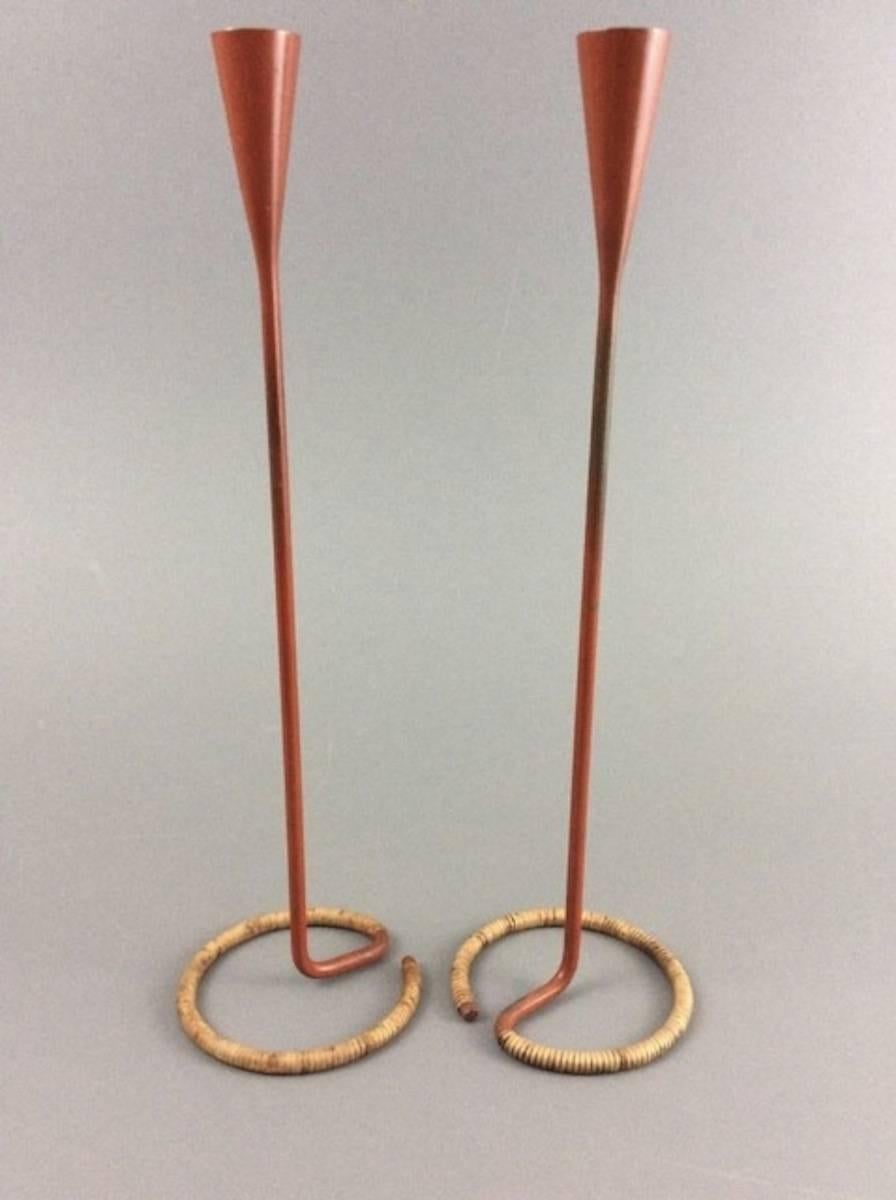 Pair of Arthur Umanoff Raymor candlesticks with wicker wrapped circular bases. Great persimmon color and patina.